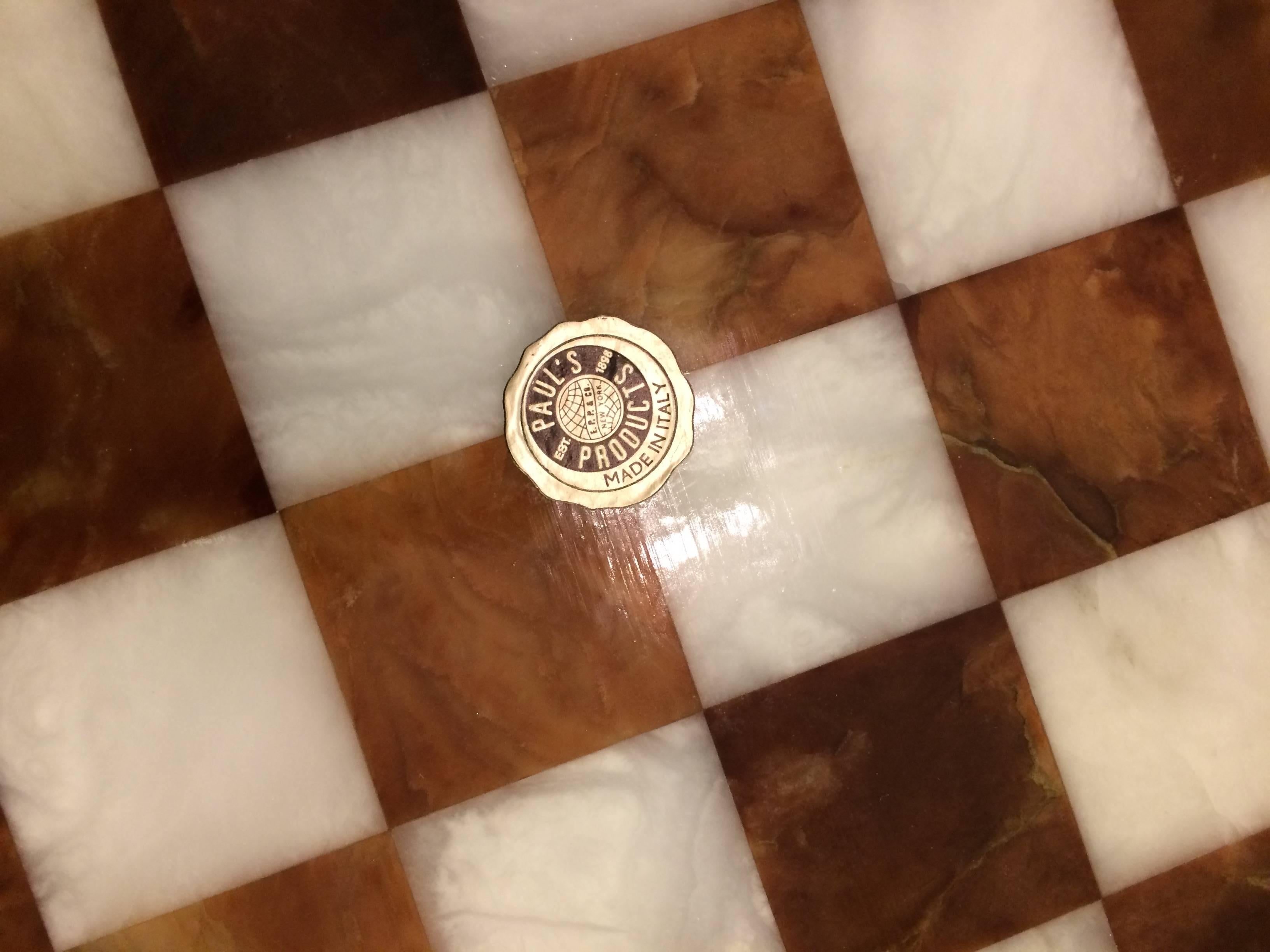 Beautifully made heavy checkers or chess board having amber and cream colored marble squares with a brass gallery. Made in Italy.