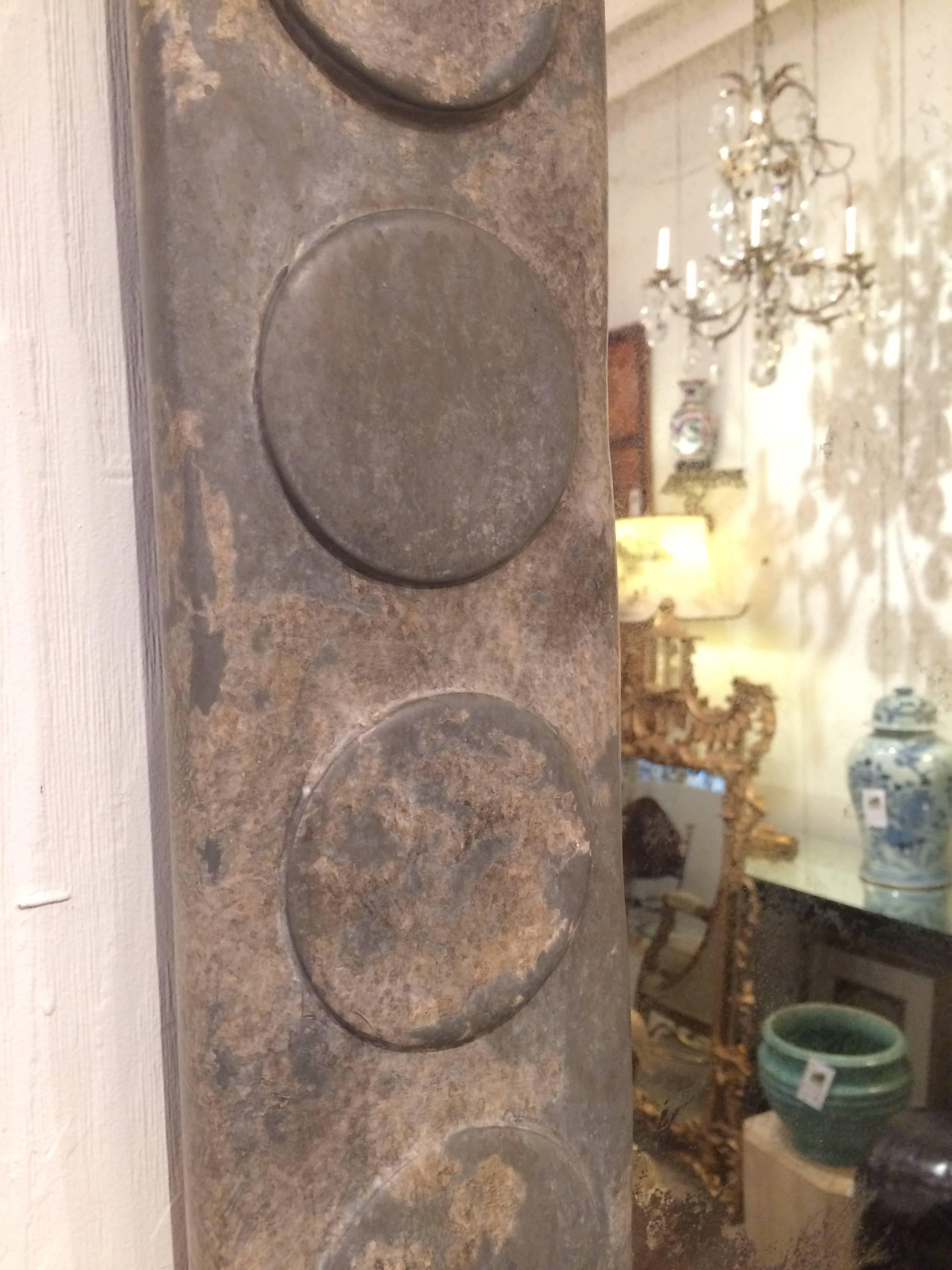 Custom mirror designed by Holly Hunt with 5" wide stunning wood frame having a distressed battle ship grey and zinc colored patina and circle motif. The raised circles (3 1/2 inch diameter) add texture and dimension, and the mirror is ghosted
