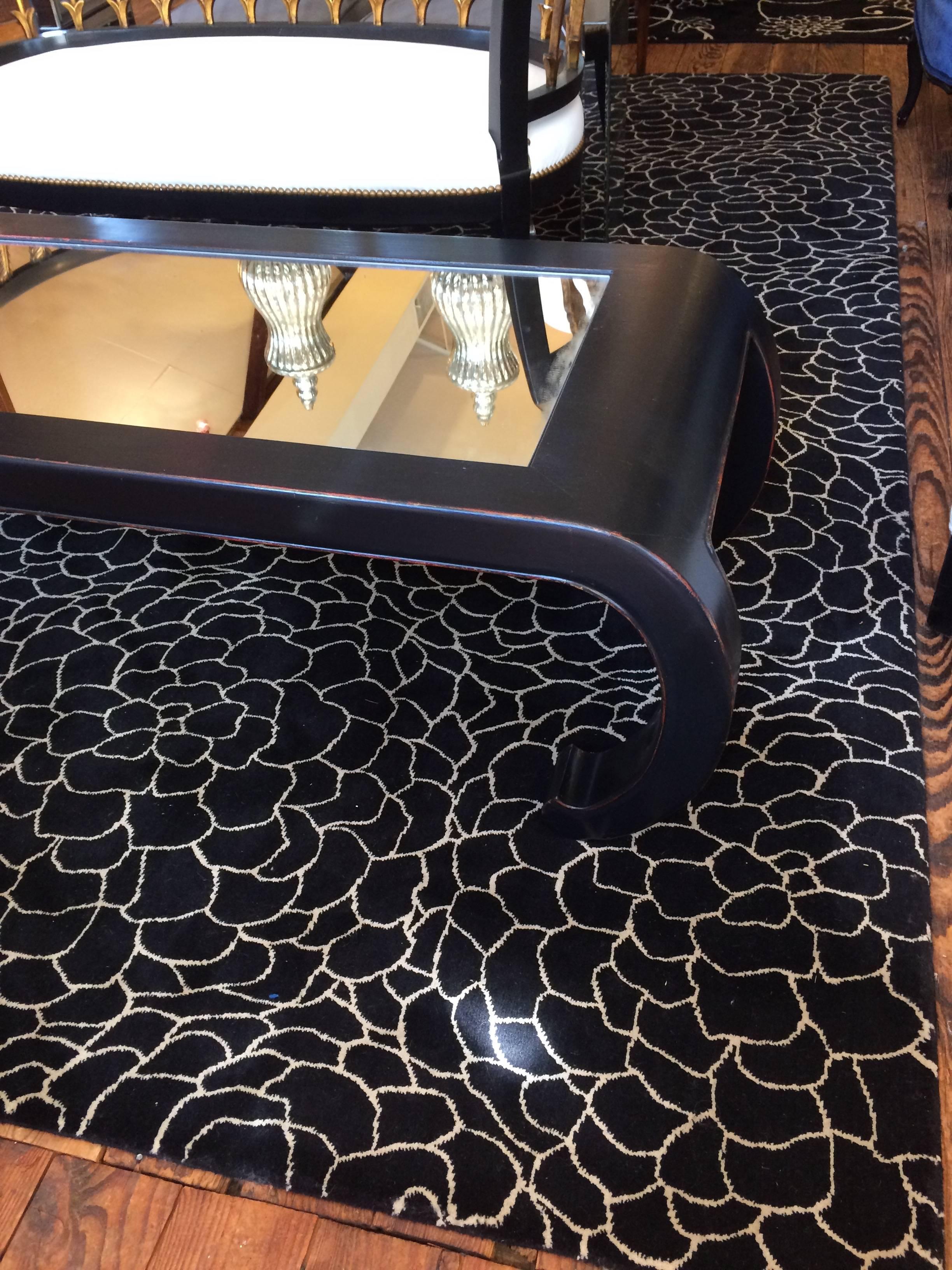 Asian inspired sleek ebonized coffee table with mirrored top.