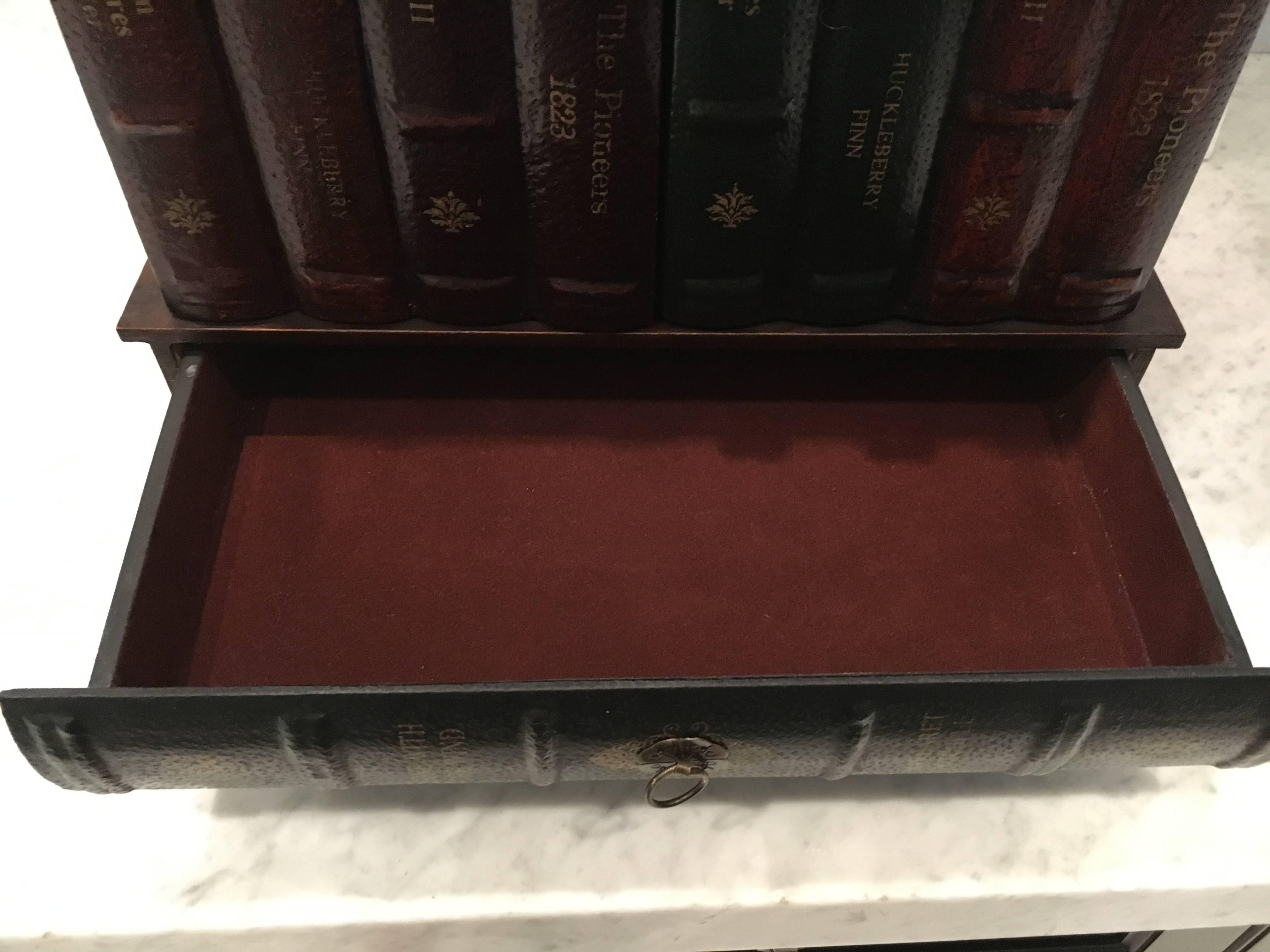 Handsome and unique vintage table in the form of leather bound books attributed to Maitland Smith. Doors open for storage having one shelf; there are three functional drawers. Brass figural feet. All original.
 