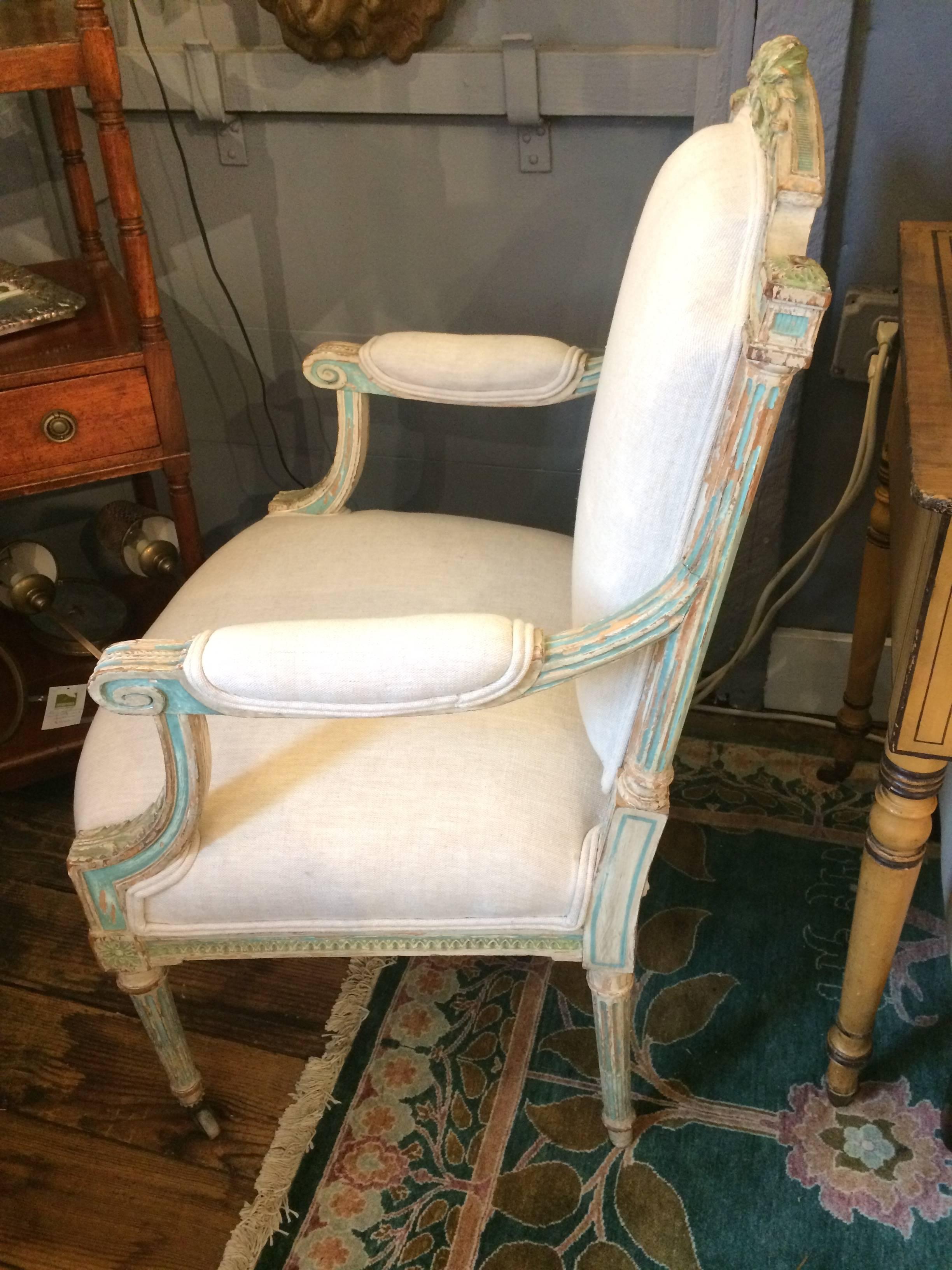 Two exquisite carved wood distressed and painted armchairs with wonderful torquoise and celadon green coloration, newly upholstered in fresh off-white linen.