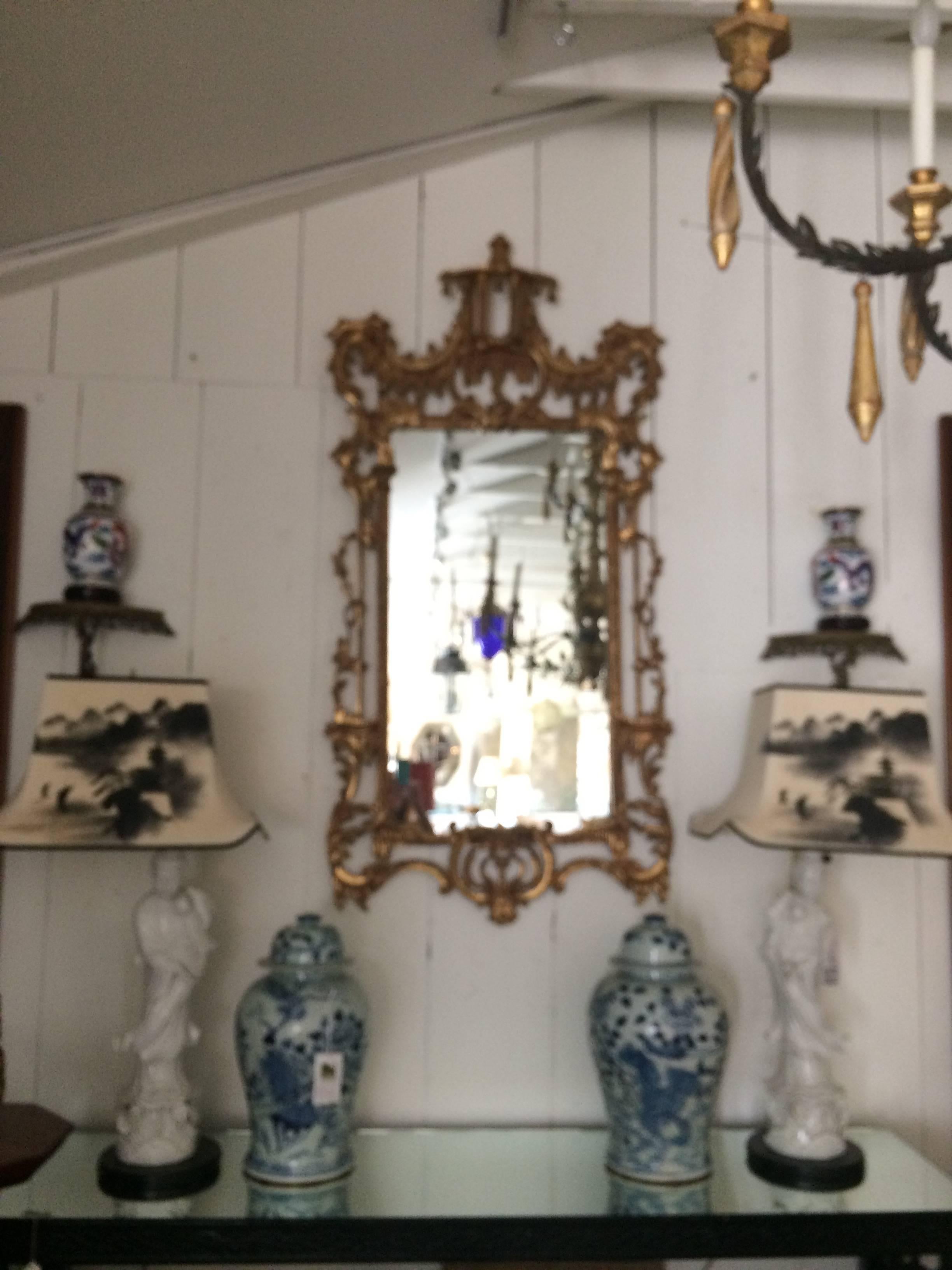 Impressive in scale, a glamorous giltwood carved mirror with pagoda at the top and wooden decorative bells. Would look fabulous mixed with Hollywood Regency furnishings.