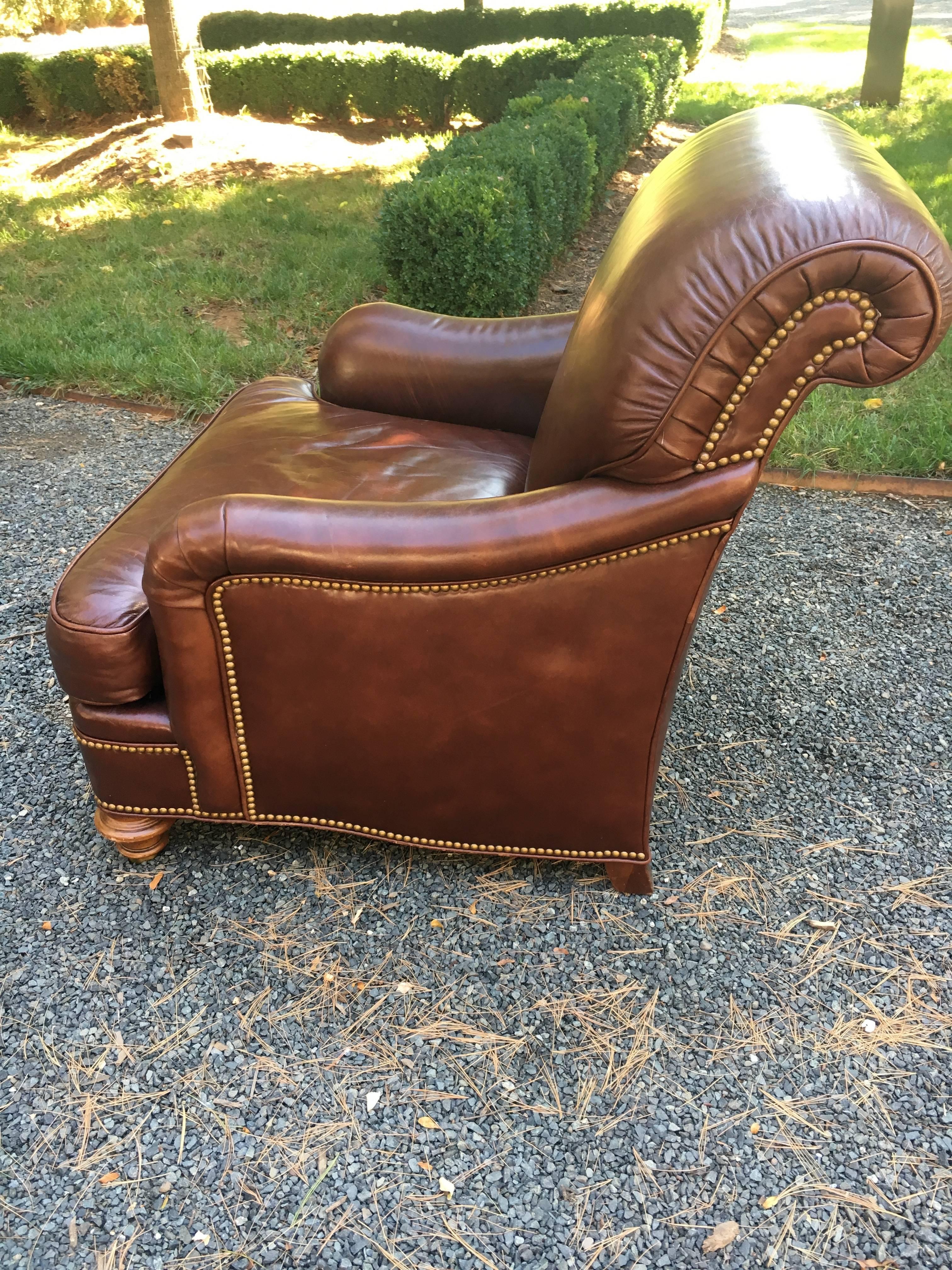 Sumptuously soft chocolate brown leather club chair and ottoman by Hickory Chair (for Greenbaum's.). A classic design, the chair and ottoman have turned mahogany legs on casters and bronze nailhead trim. Measures: seat height 18 (with cushion), seat