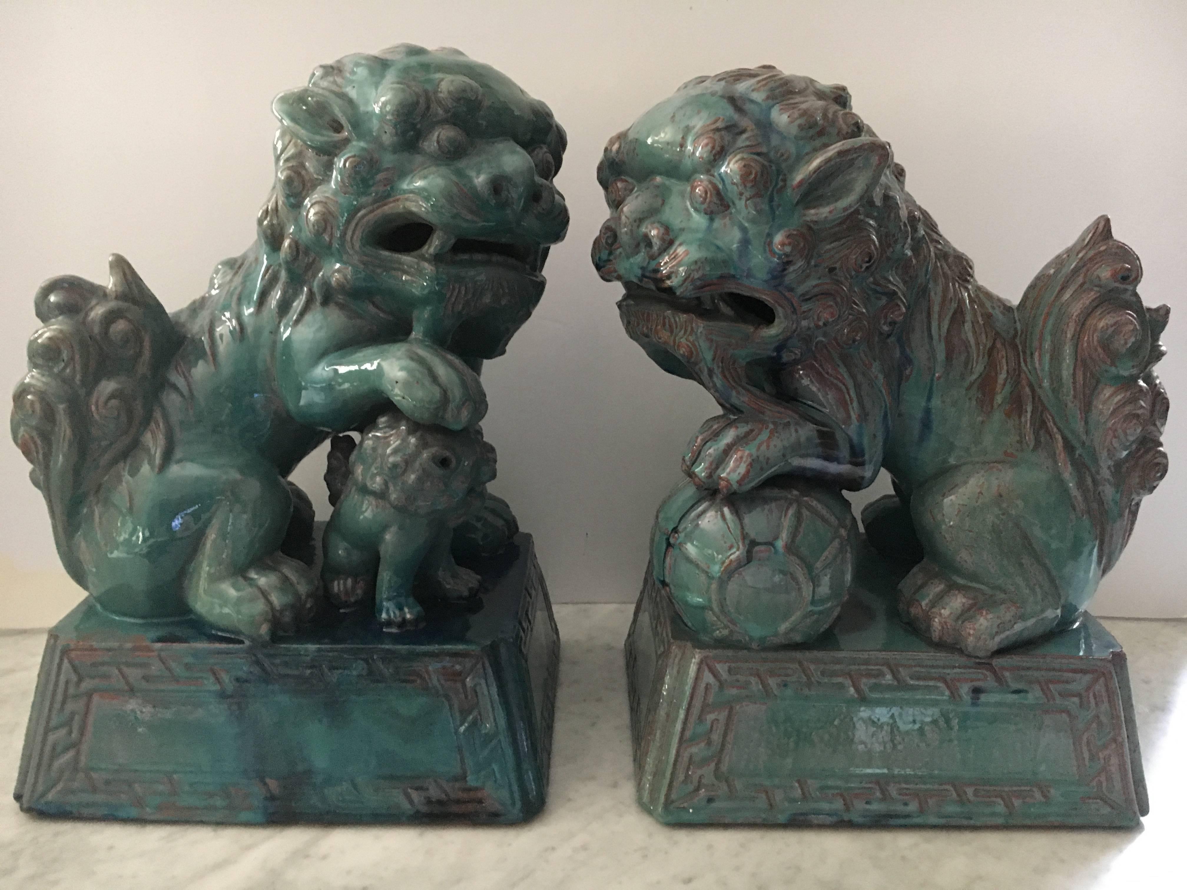 Large pair of male and female Chinese foo dogs in wonderful turquoise glaze over thick ceramic clay. The glaze has a wonderful patina, with some chocolate brown highlighting. There are no chips or scratches.
 