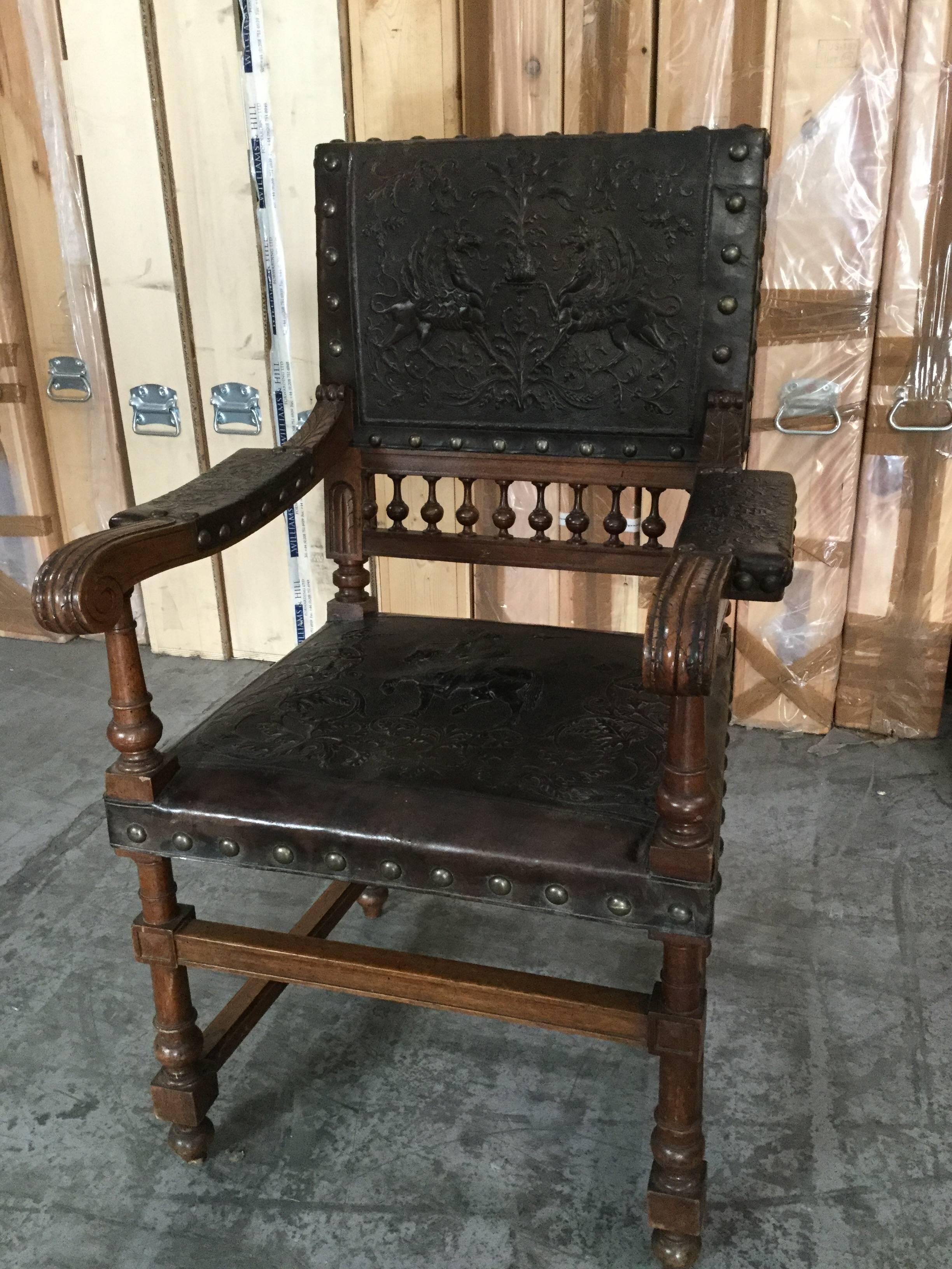 This Spanish tooled leather arm chair features an oak, carved frame, squared arm rests, beautiful decorative leather seat and back adorned with horses, riders, and lions. Large brass nail heads finish off the details. 

Measures: Height to arm is