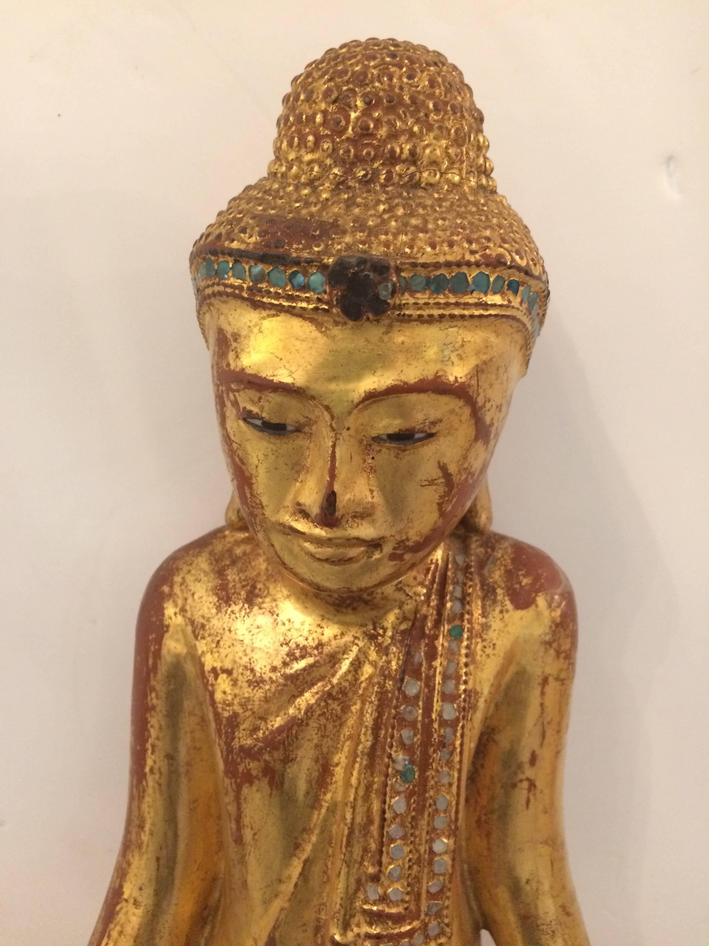Medium sized beautiful carved giltwood Buddha with meticulous detail and glittery rhinestone decoration across the top of robe.