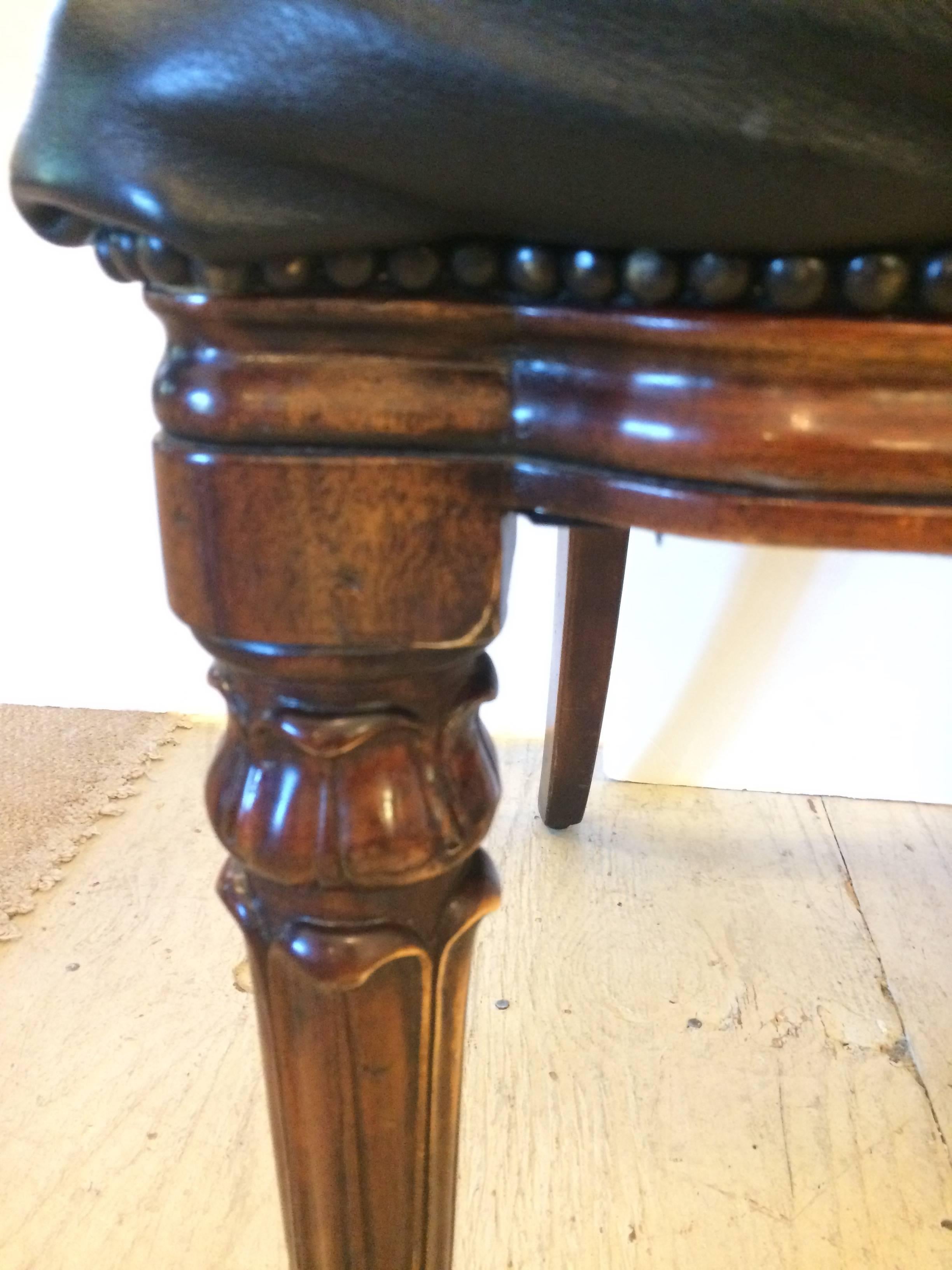 Handsome rich black leather tufted side chairs having carved wood legs, nailhead detailing and wonderful cut outs in the back for easy handling.  We sure they are Theodore Alexander, but no label.