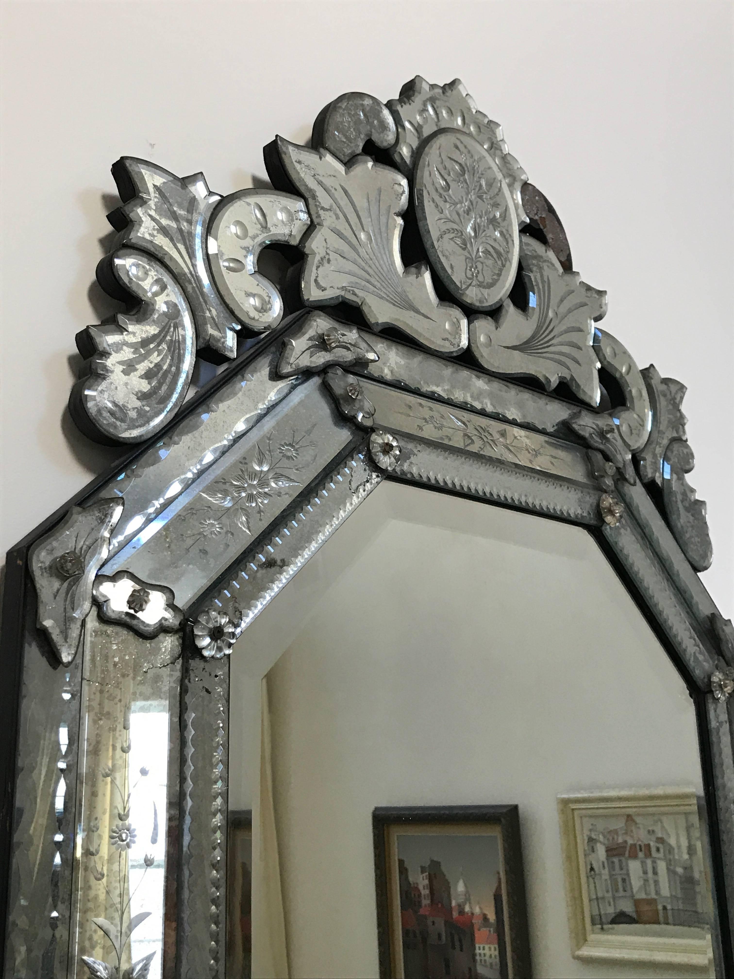 Large fancy Venetian mirror with an octagonal shape, etching around the periphery, and wonderful decoration on top.