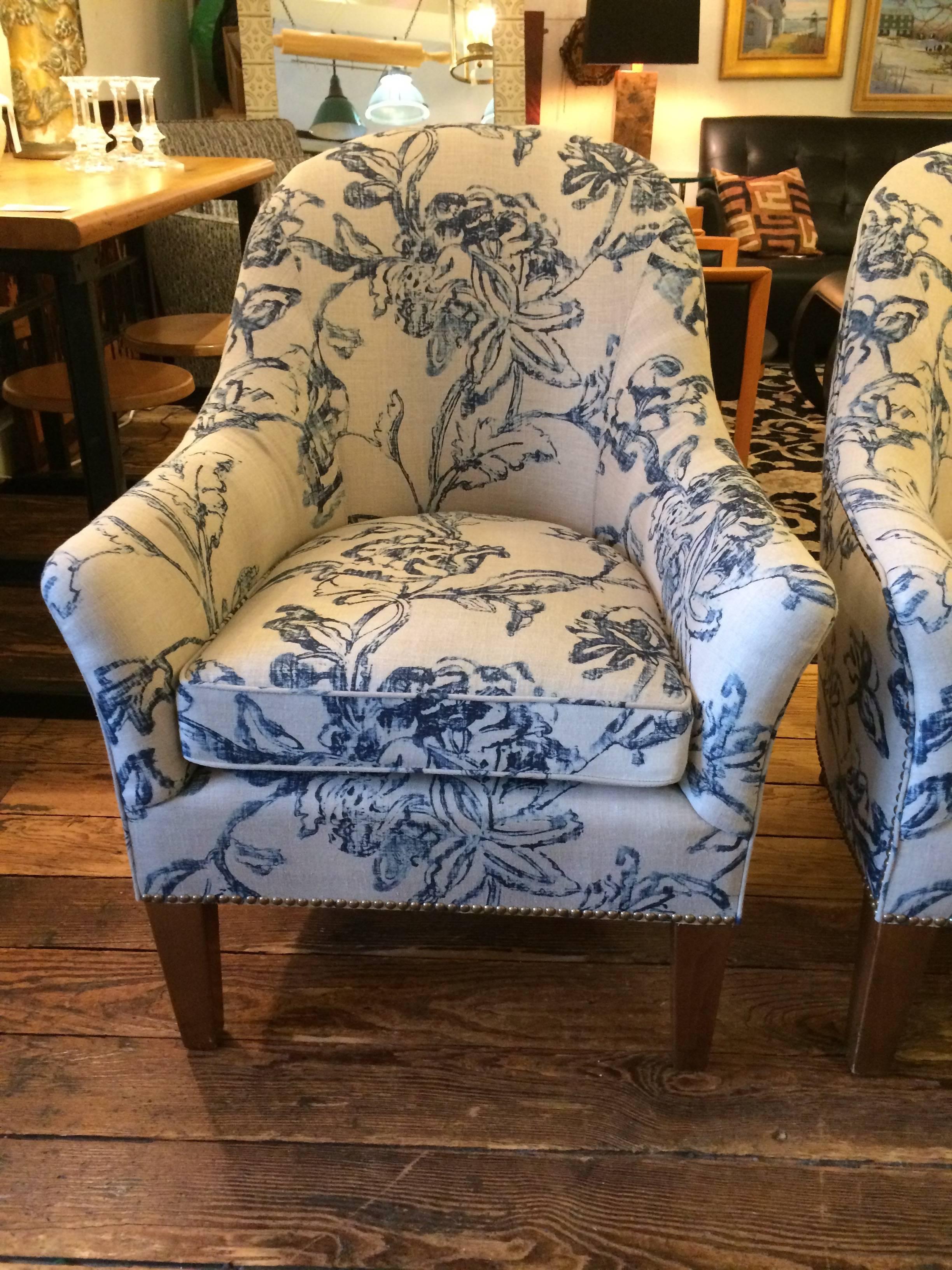 Lovely pair of contemporary Classic club chairs, custom-made, very comfortable and upholstered in a blue and natural white linen floral fabric. Finished with decorative nailheads.