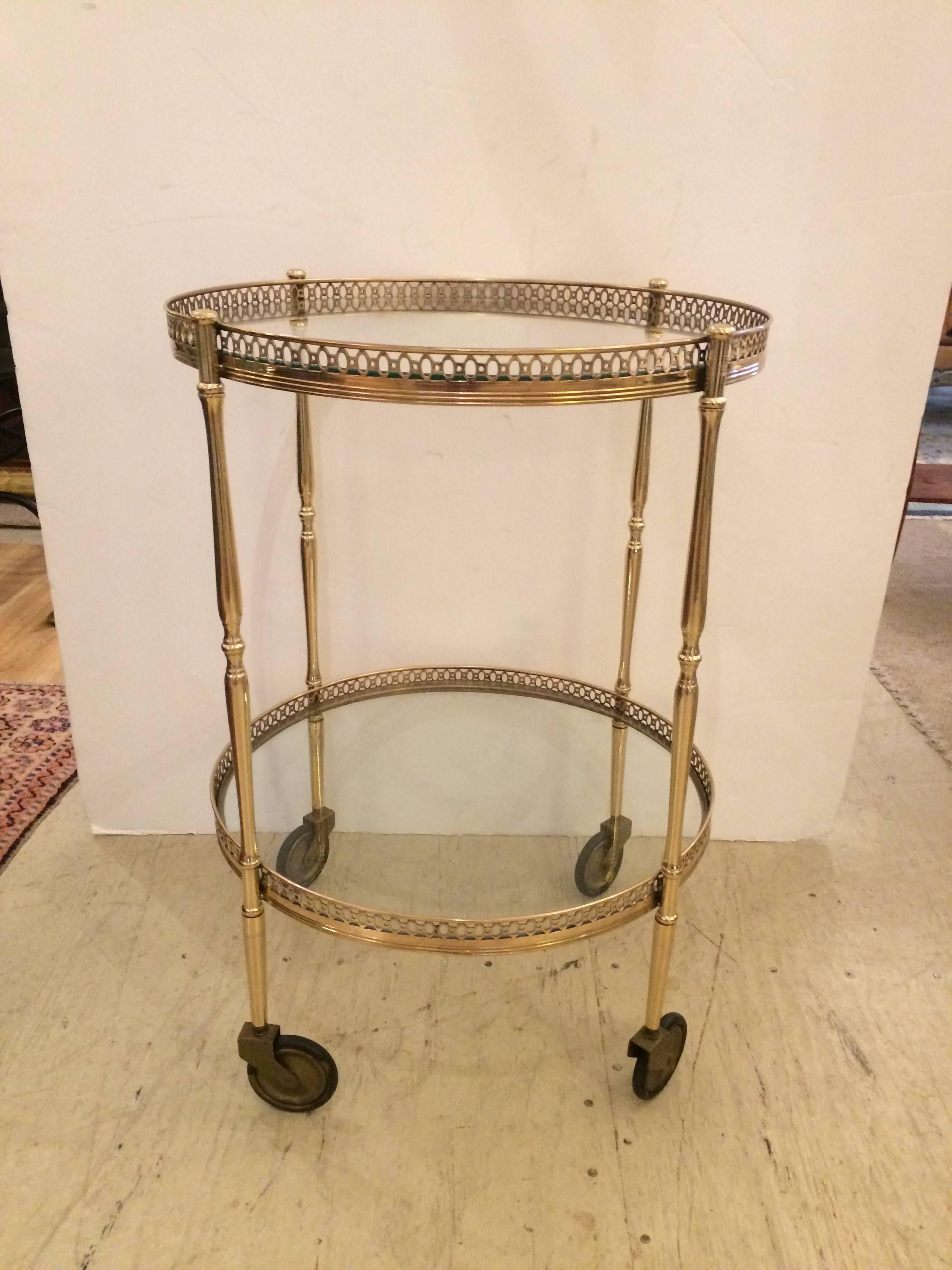 Elegant round bar cart having two circular tiers with gorgeous brass galleries, professionally polished and on casters. Bottom tier is 10