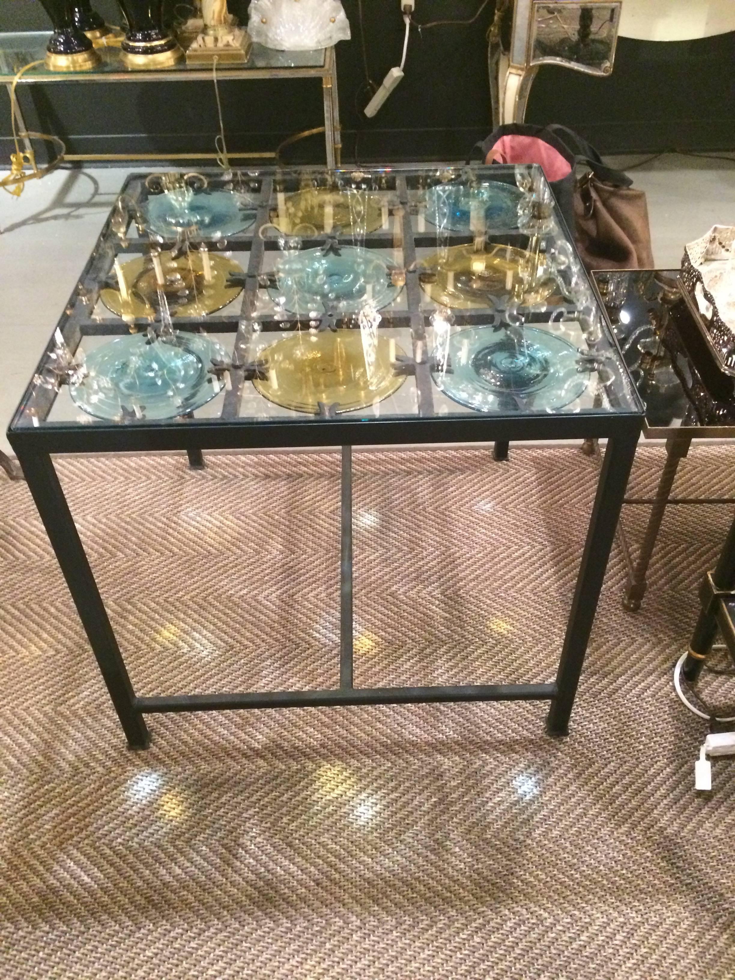 Two wonderful square side or end tables having black metal bases with gorgeous hand blown glass disc tops of turquoise and gold covered with clear glass surfaces.
 