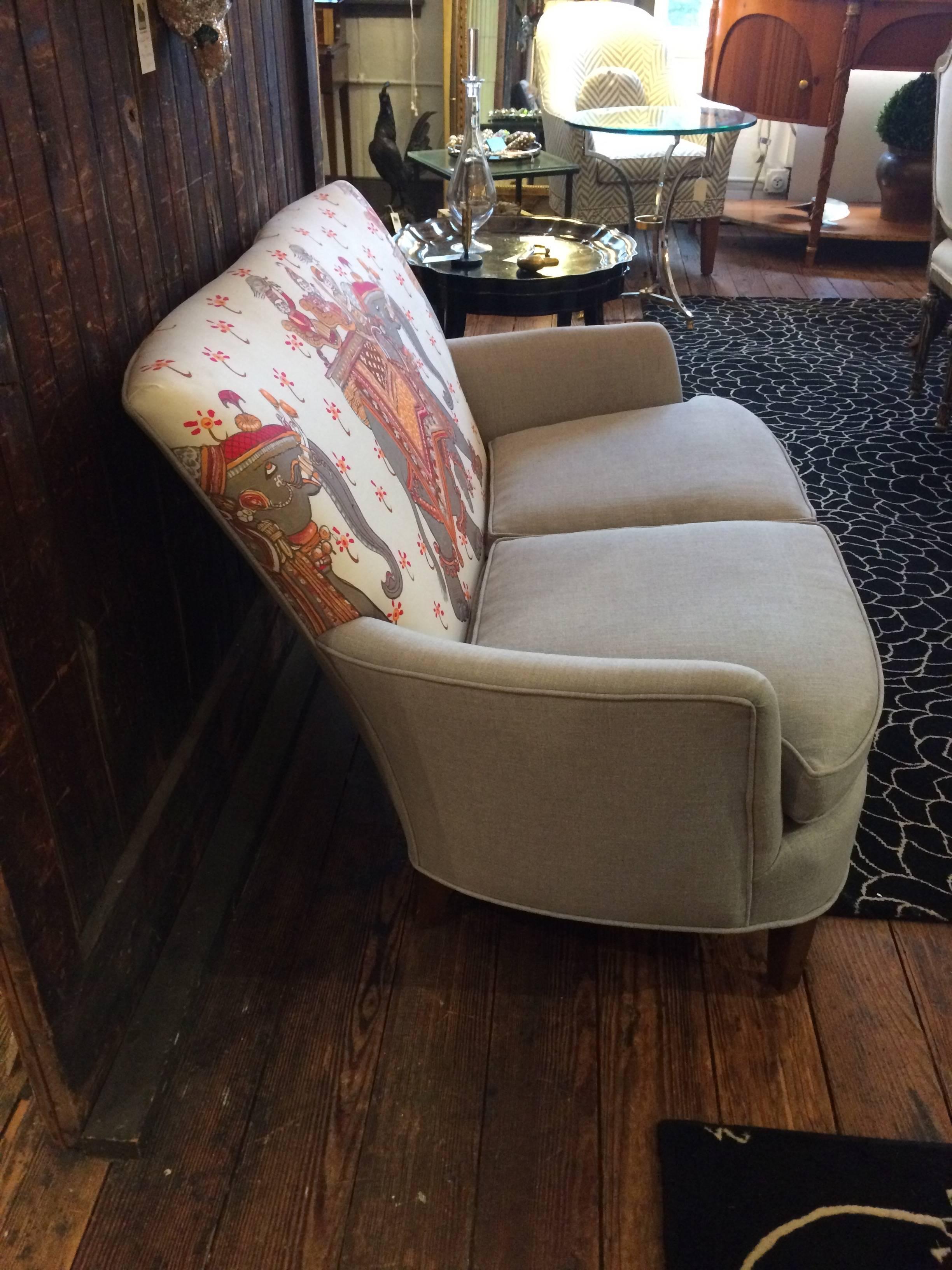 Gem of a sexy low slung antique loveseat from France having mahogany tapered legs and recent neutral grey upholstered seat and fabulous Hermes elephant motif back in cream, grey and orange.