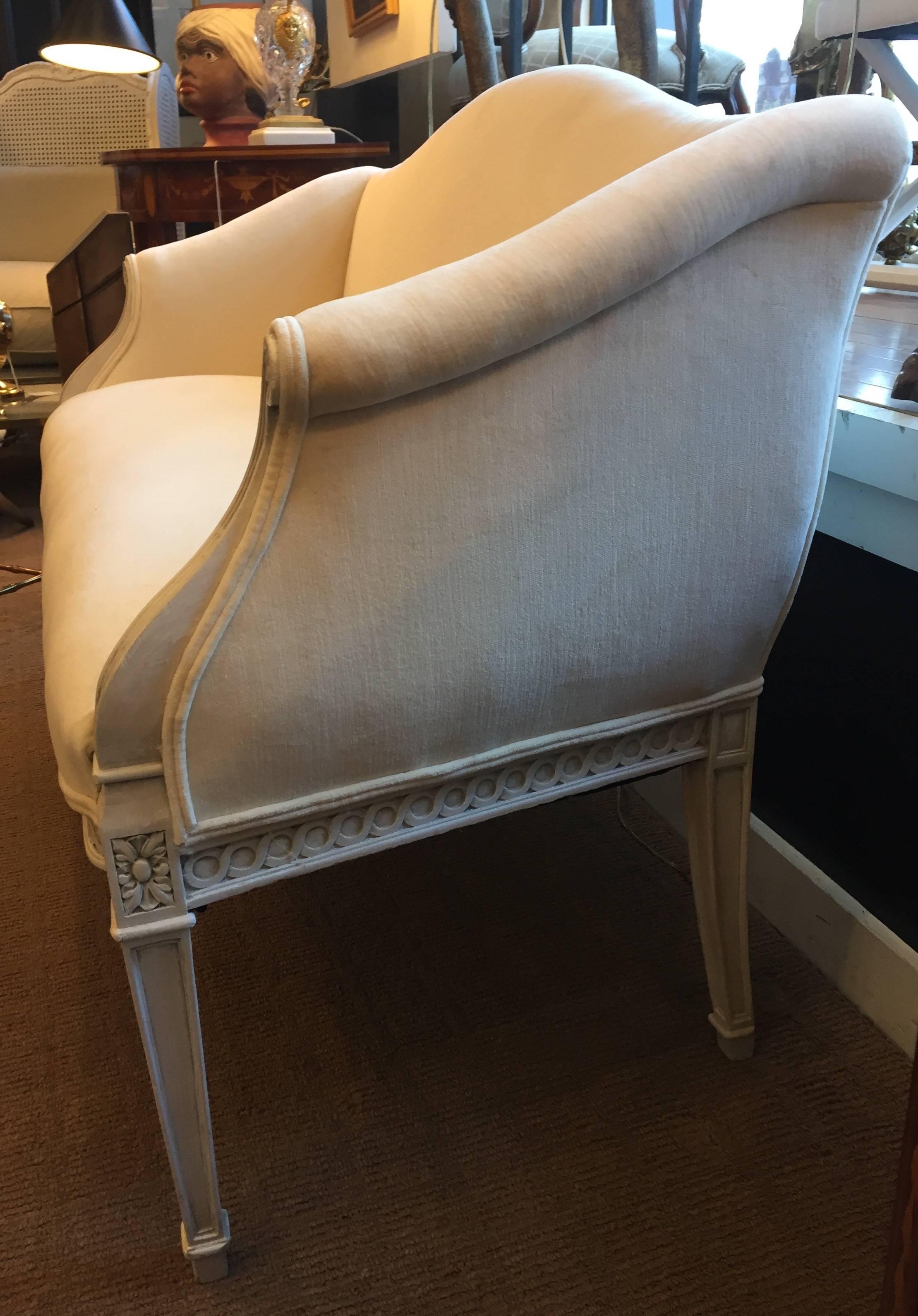 Lovely diminutive carved painted walnut and upholstered bench loveseat in a 
 creamy French white with a touch of grey and fresh new elegant cream cotton velvet upholstery.
  