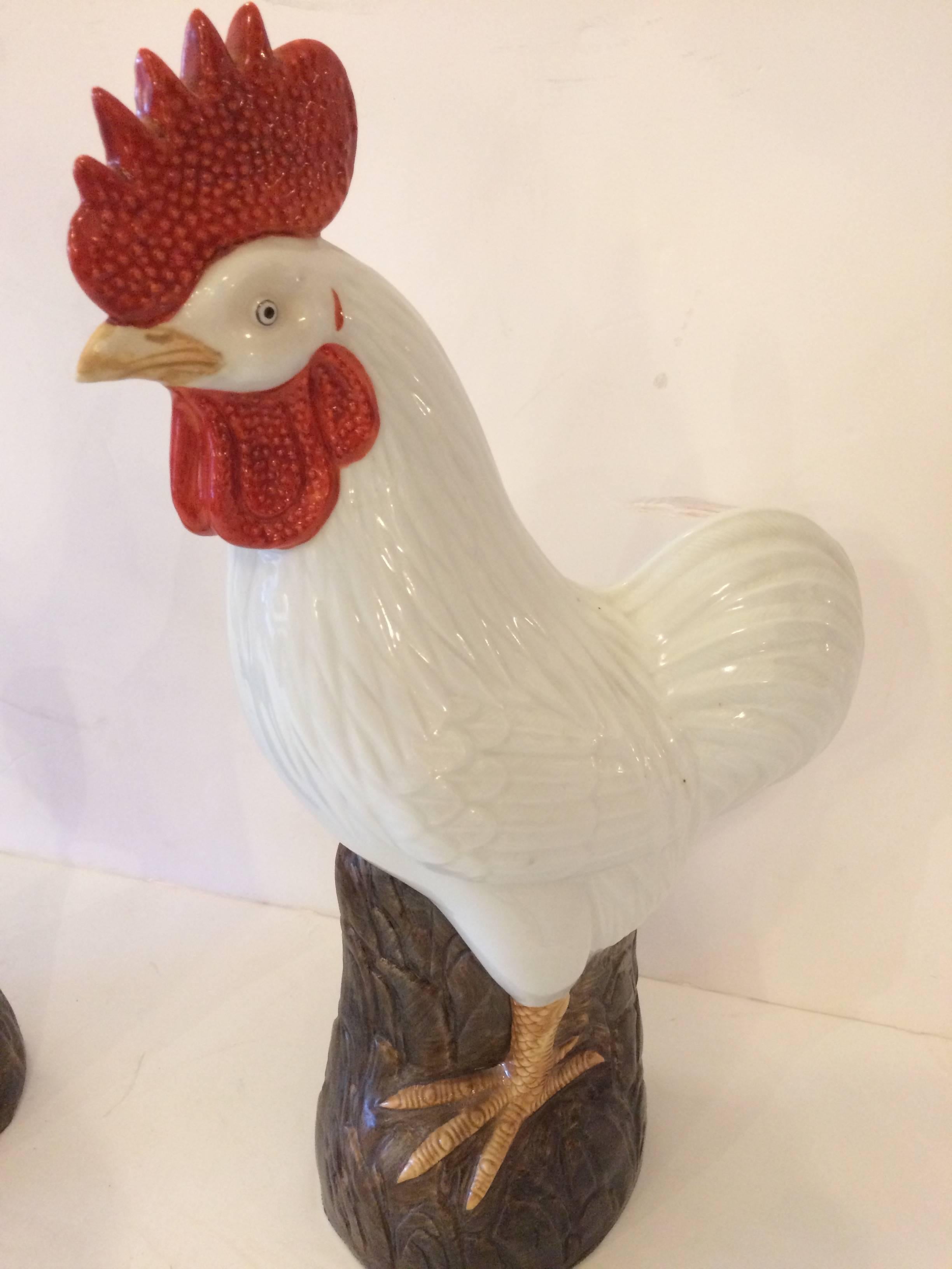 Delightful pair of porcelain roosters in white and red with brown bases.