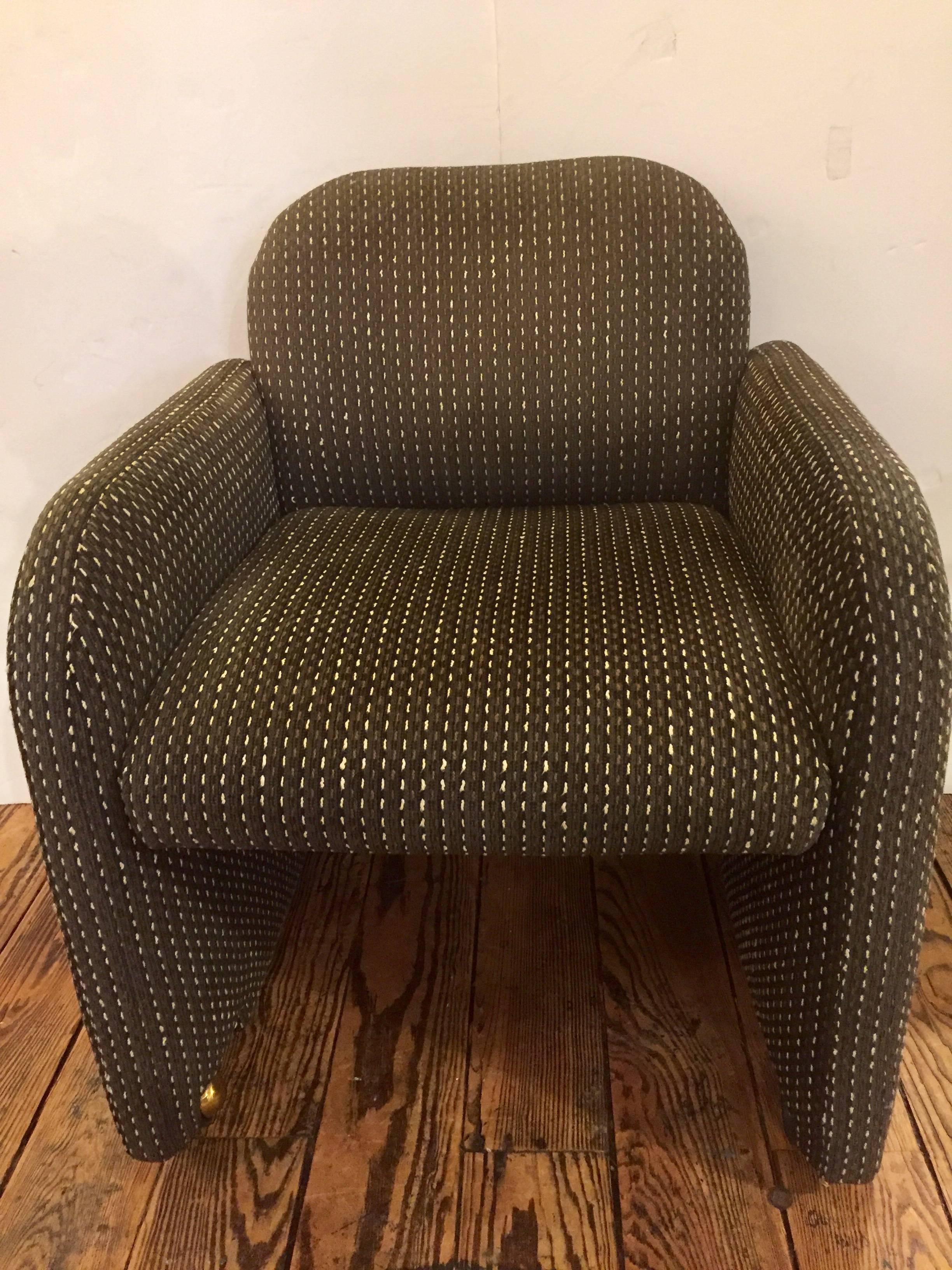 Very comfortable box shaped handsome Mid-Century Modern upholstered club chairs in a brown tweedy fabric on brass casters. A set of four are available.
Measures: Seat height 18”.