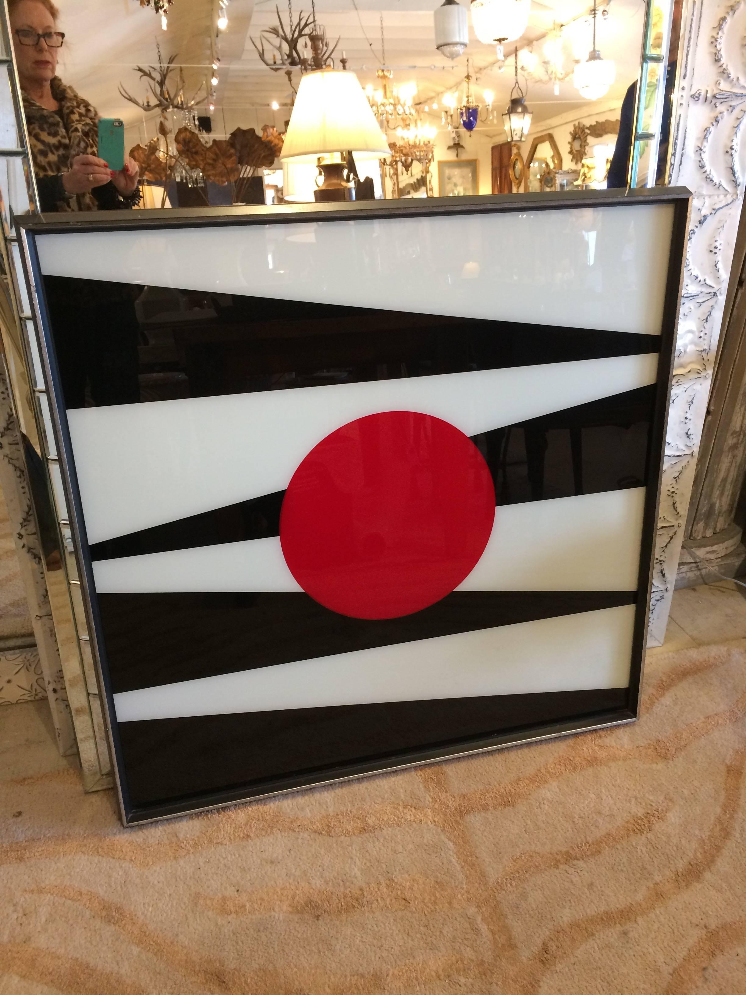 Very graphic Op Art style reverse painting on glass having a bold geometric design in black and white with a central red circle.