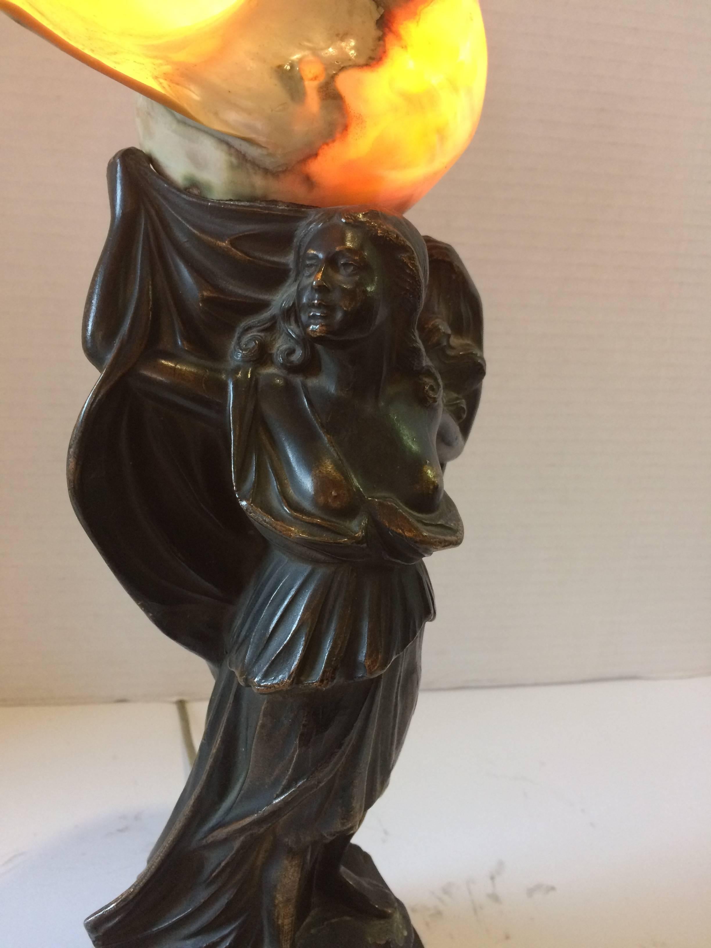 A true objet d'arte deco lamp having a sculptural figure of a long haired goddess topped by a glistening mother of pearl lined conch shell that illuminates. Was originally a lamp as well as a radio speaker (not functioning), signed Tonks Brothers,