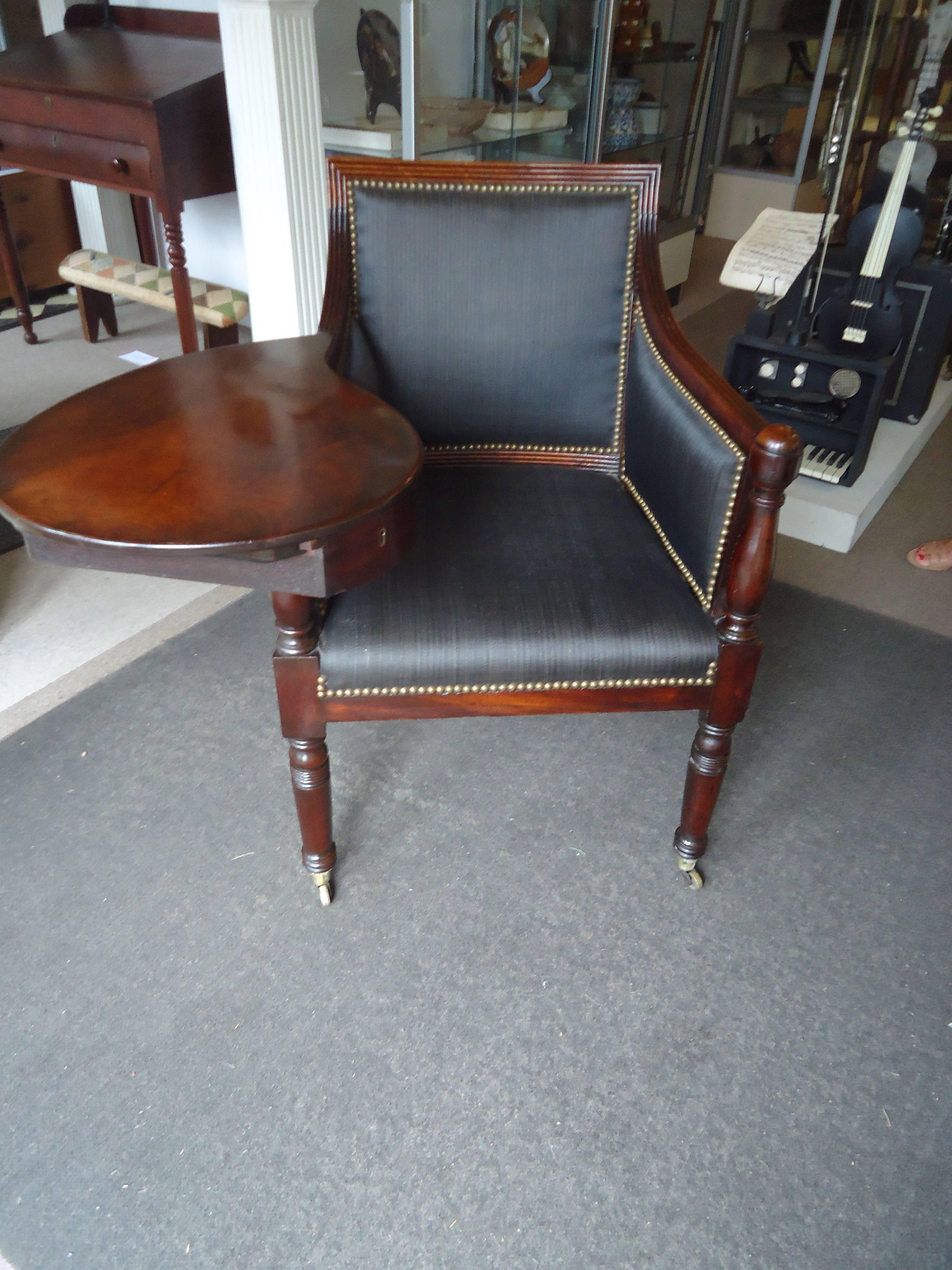 Very unusual Federal writing chair having a reeded frame upholstered in black horsehair and tack trim, with a large writing surface on the right and a sliding drawer underneath fitted with compartments for inkwells, all resting on turned legs with