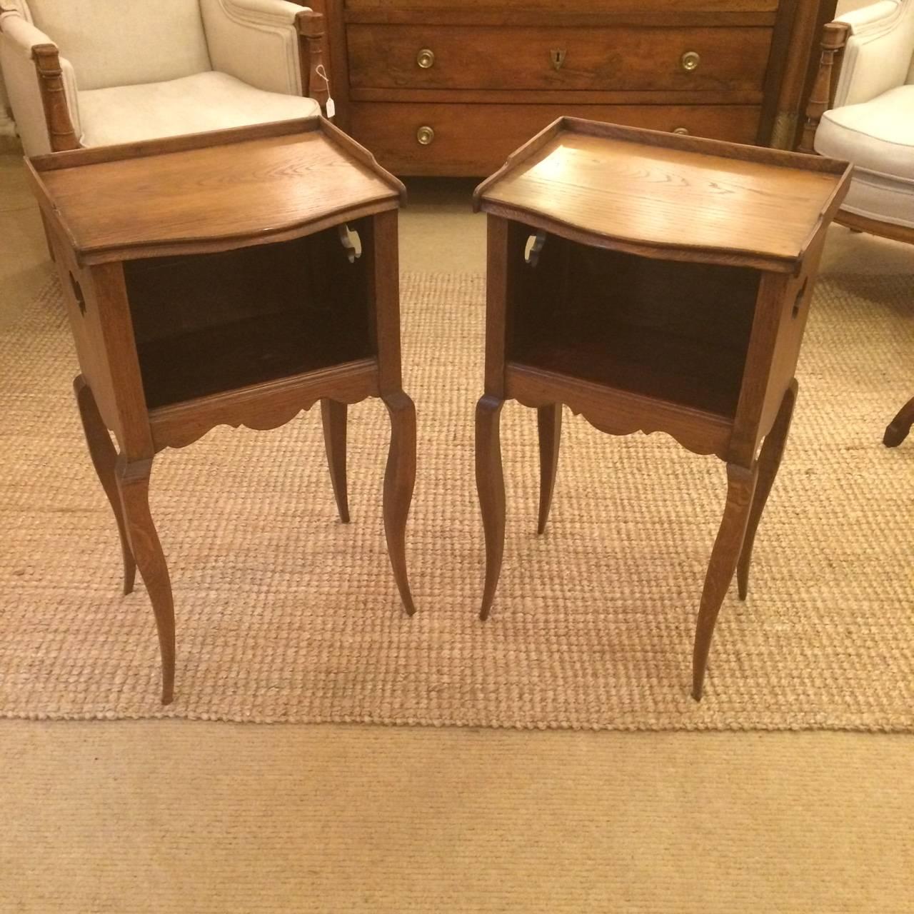 Lovely pair of night stands or end tables from Paris, France, circa 1860, having wooden gallery around top surface and storage room underneath and pretty saber legs.