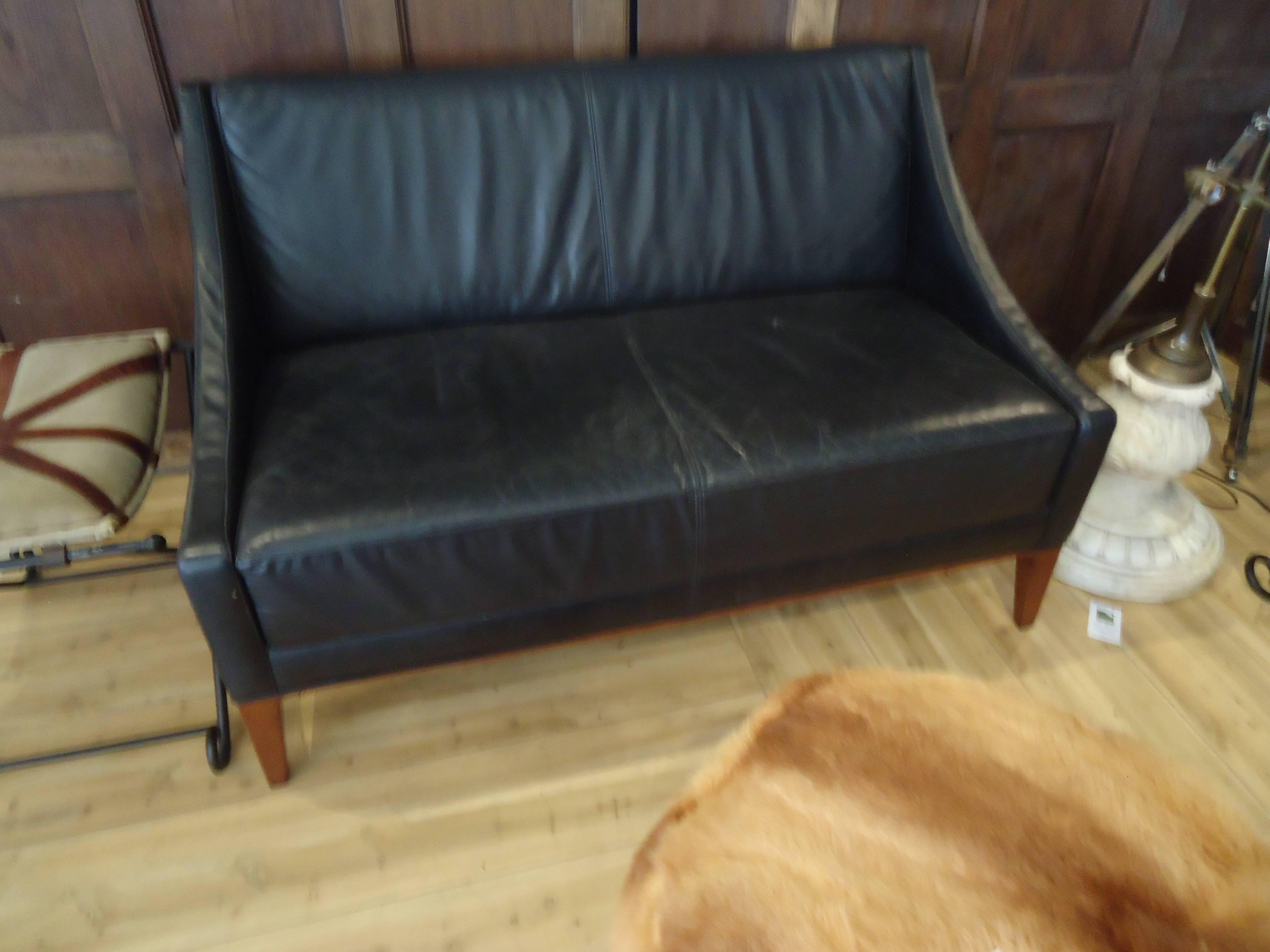 Sleek black leather Mid-Century Modern pair of loveseats. Compact, comfortable and chic. Sofas also available.