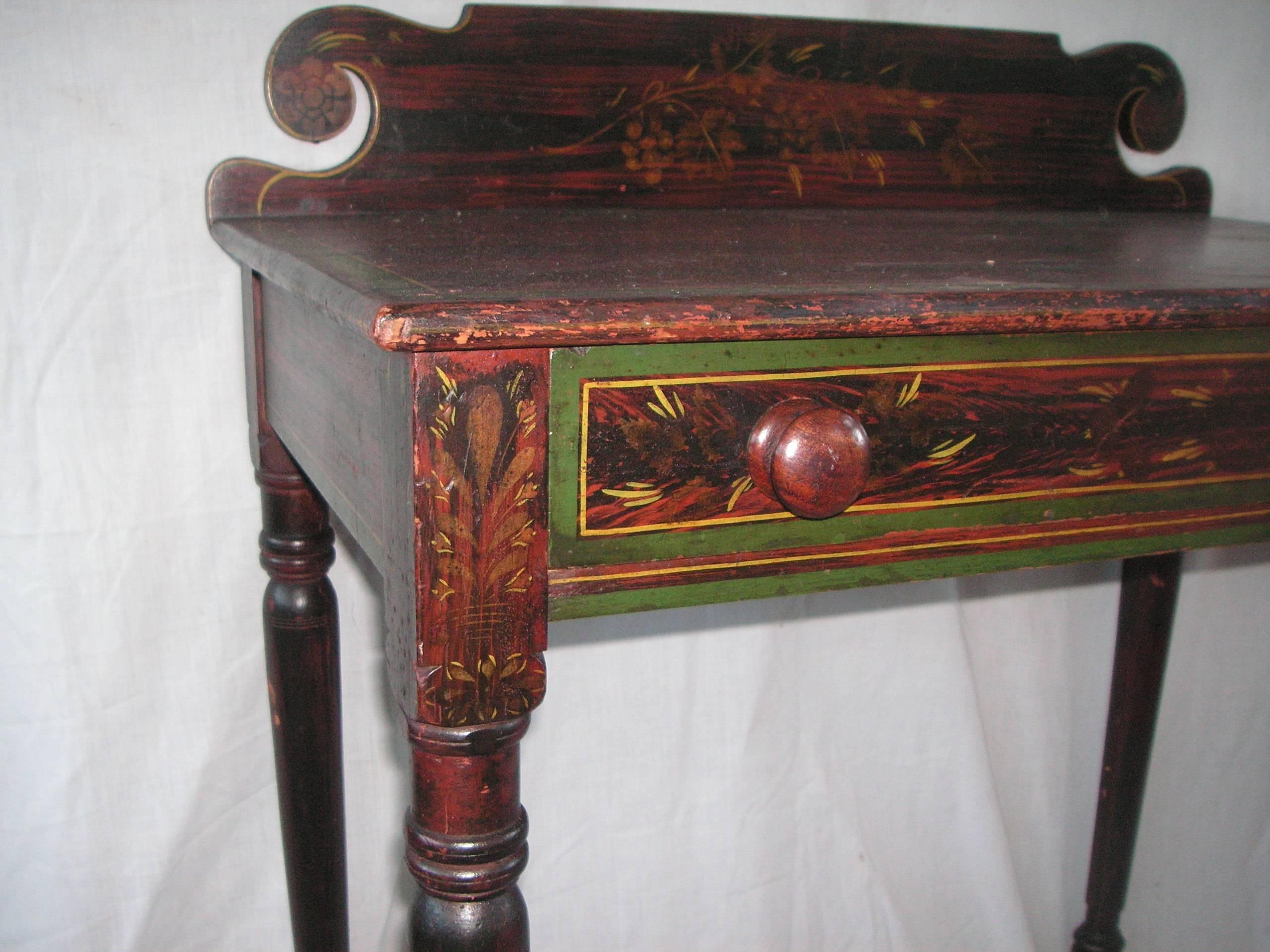 Mid-19th century New England one drawer dressing table with original paint. The paint decoration is faux rosewood with green and yellow striping and gold stenciling. It is in very good condition with lovely notched detail at the top of the front
