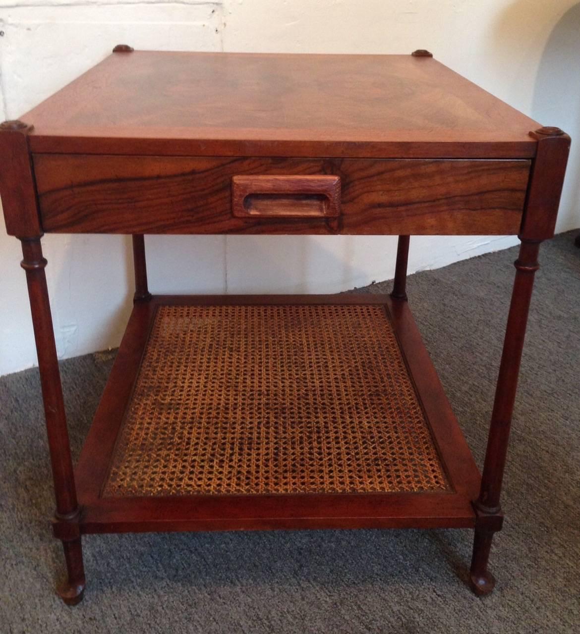 Beautiful Mid-Century Modern burl wood and cane accent table by Baker with single drawer. Gorgeous graining on top and one cane shelf below.
Baker Furniture Company label inside drawer.

Measures: 24 inches high (60.79 cm).
21.75 inches wide