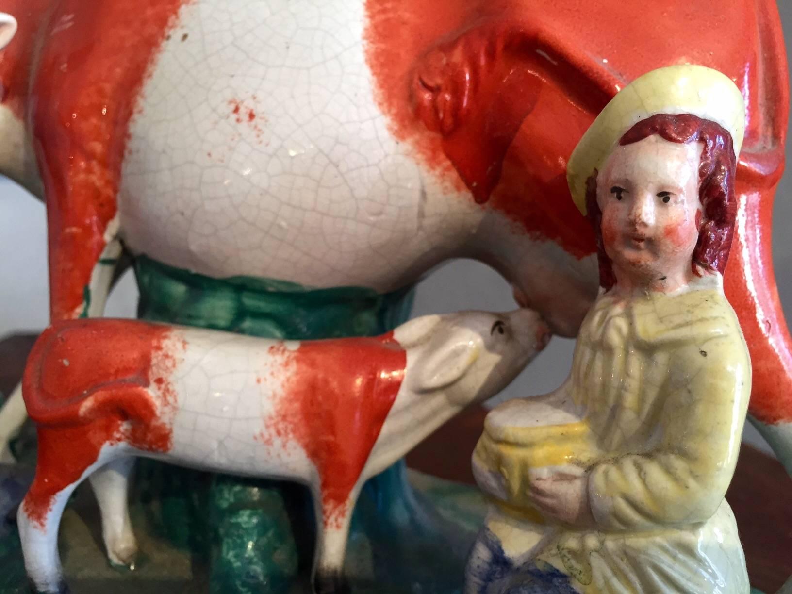 Whimsical and charming pair of earthware vases having cows and maids milking them and adorable calves taking a drink from mother cow as well. Obvious age but in excellent condition except for one small chip to one cow's ear as shown in detail photo.