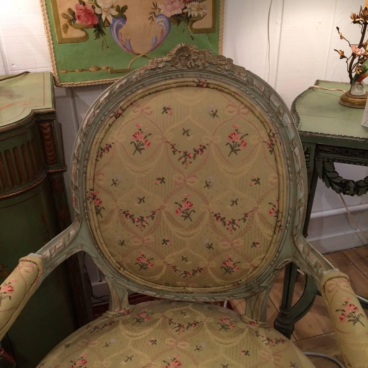 Gorgeous French Louis XVI style armchairs having carved painted wood frames in a soothing pale celadon green, upholstered in uber elegant Schumacher fabric. Arm height 25.75.