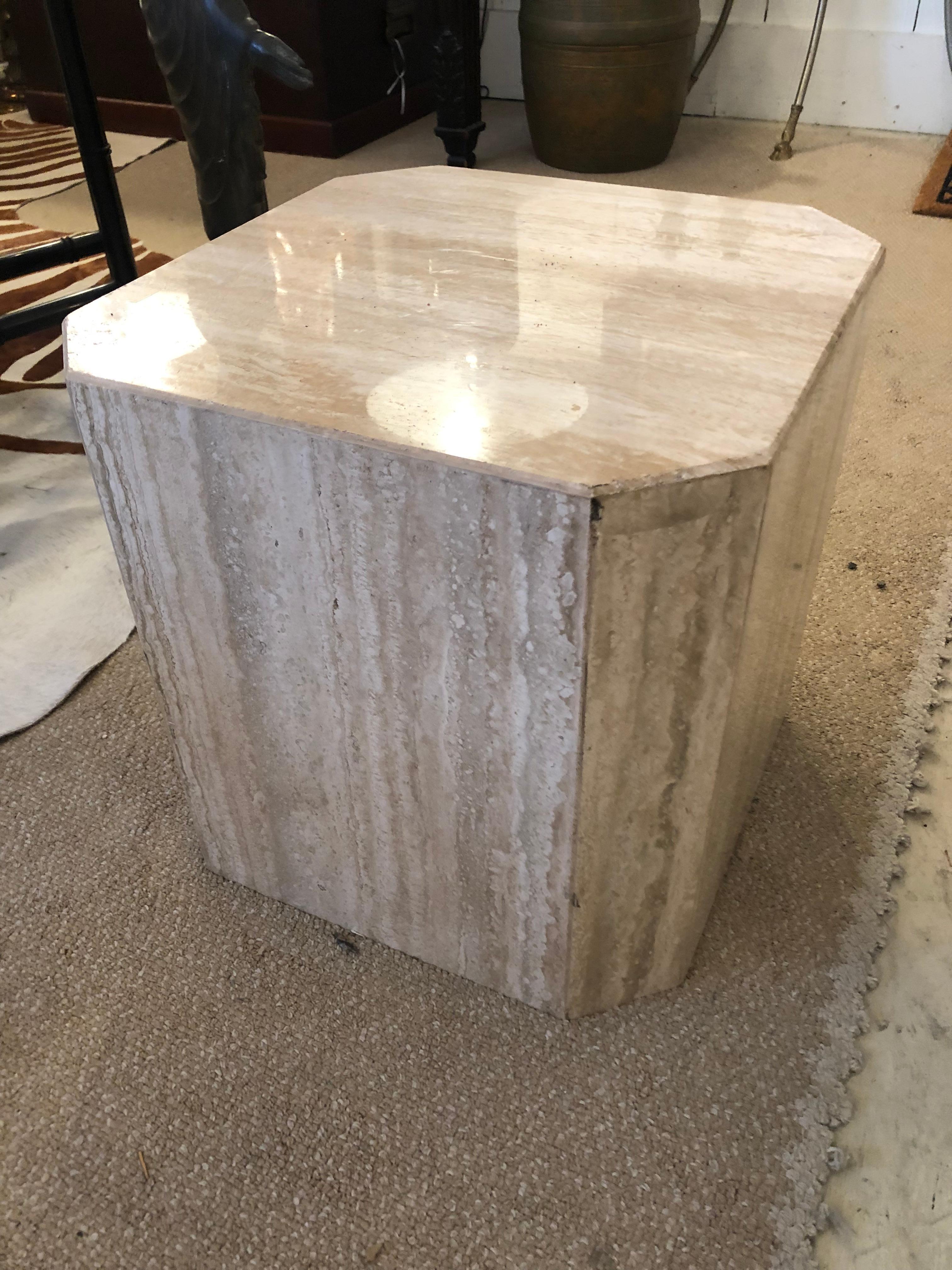 Sleek but chunky cube of travertine with squared off corners makes a glamorous little drinks table.