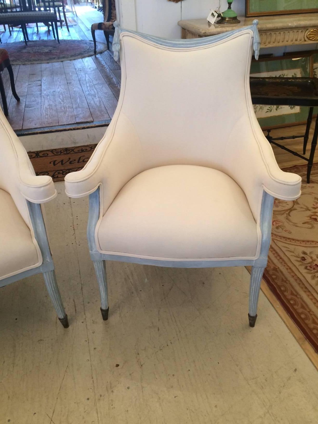 Super stylish armchairs by Grosfeld House with grey blue carved wood having decorative swags at the top and reeded legs with capped feet. Very glamorous Hollywood Regency style and newly upholstered in crisp white duck.
Measures: Seat height 19