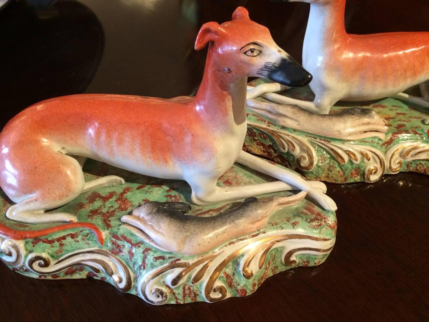 Wonderful pair of vintage Staffordshire having reclining hunting dogs and rabbits, beautiful gold leaf decoration on the edges.