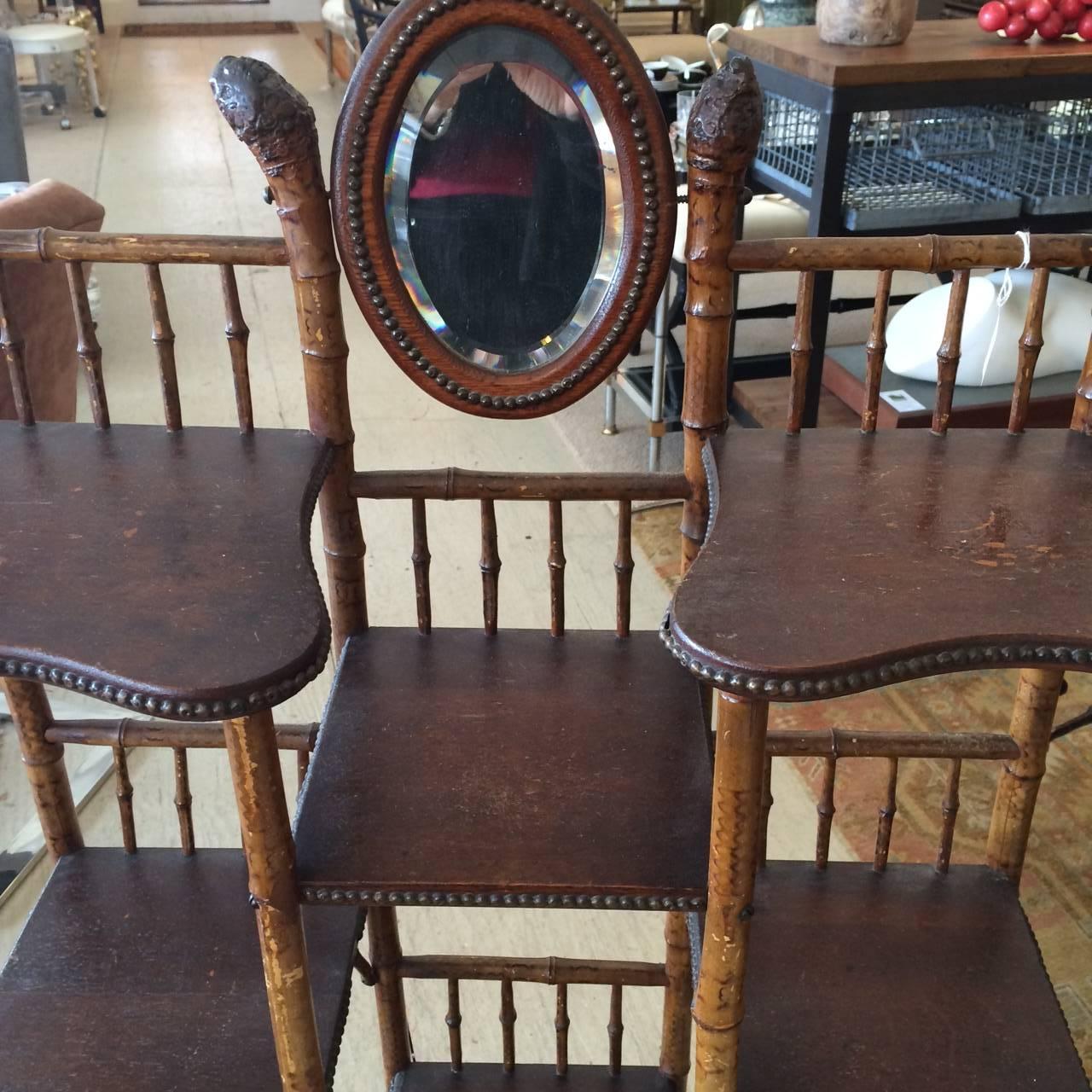 Lovely multi shelved etagere with root bamboo structure and small pivoting oval mirror at the top.