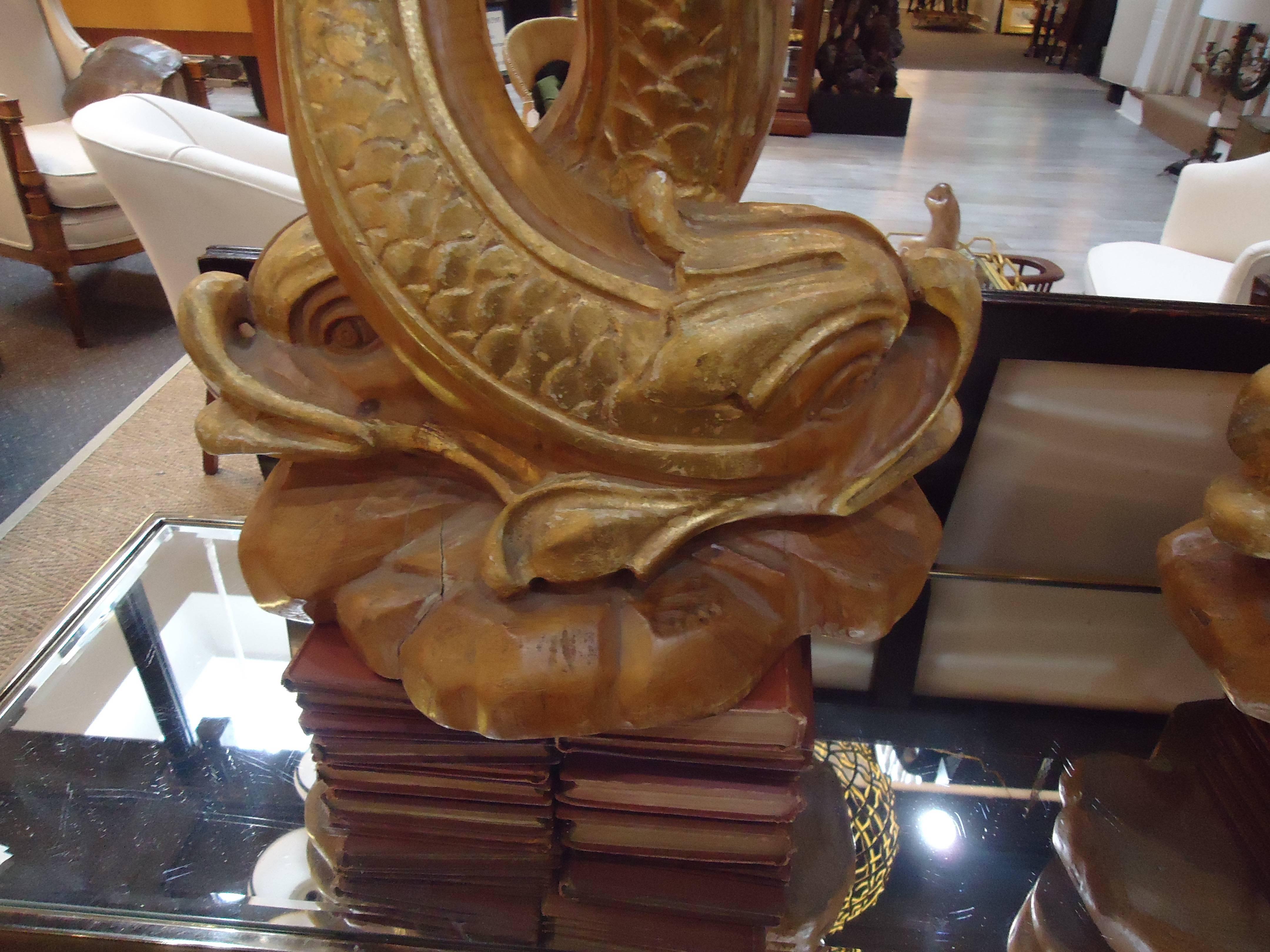 Estupenda pareja de estatuas de delfines de estilo chino talladas en madera dorada Regencia de Hollywood en venta