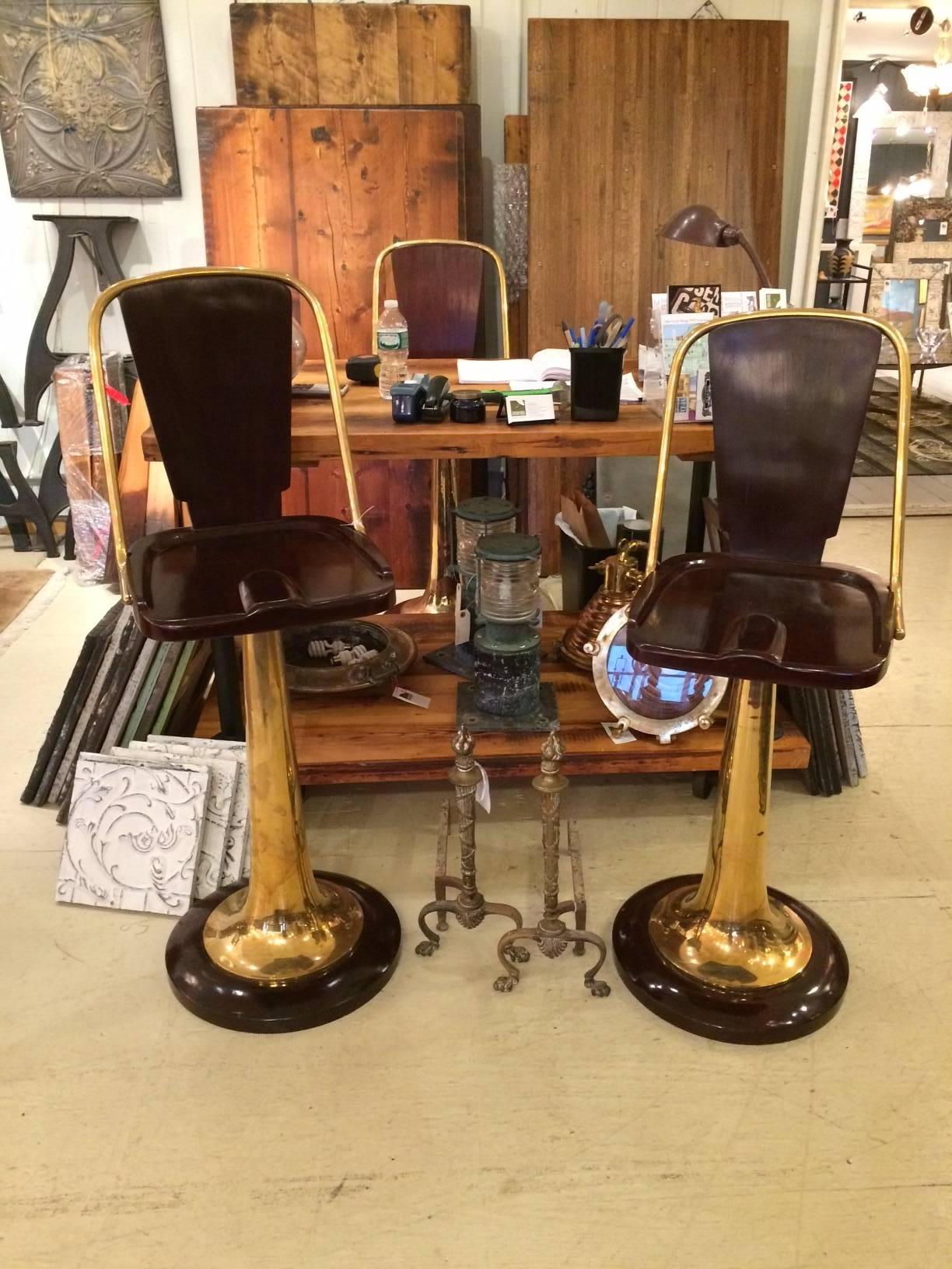 Regal trio of Art Deco barstools that look like they once graced a luxury yacht, having gorgeous polished mahogany seats, backs and bases and brass bases and sides. Bases are 19