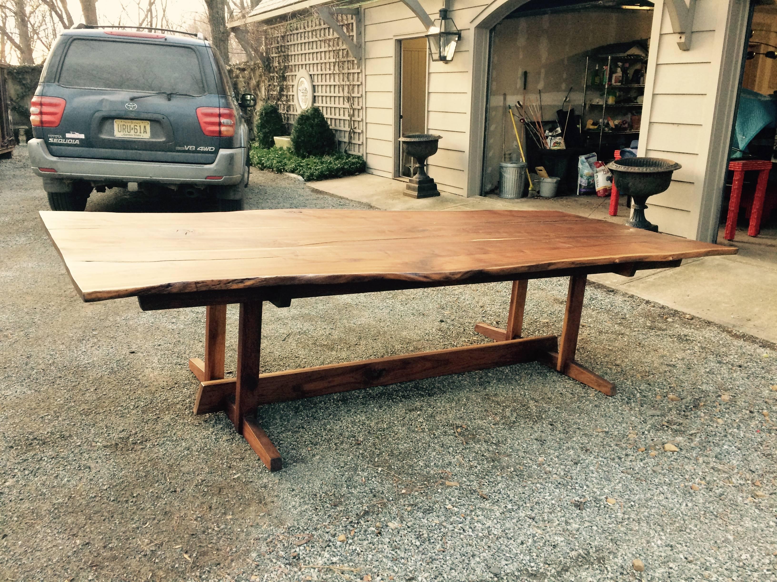 A magnificent 10 foot long finely figured walnut dining table handcrafted as a custom commission by Dean Perkins of Tree Spirit Tables, with sinuous live edge slab tabletop on elegantly proportioned trestle base. Marked with Tree Spirit Tables brand