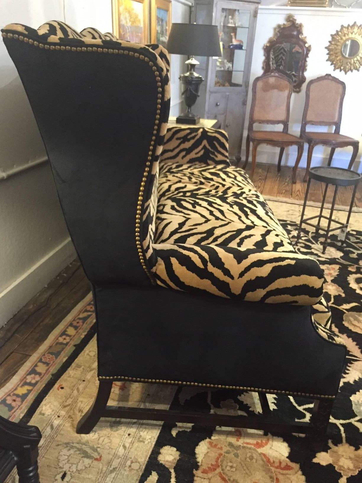 Showstopper of a sofa, over the top and glamorous having a wonderful wing chair shape with very high back, curved sides and arms, carved mahogany base and feet, dressed up in luscious camel and black zebra patterned mohair on the front, black mohair