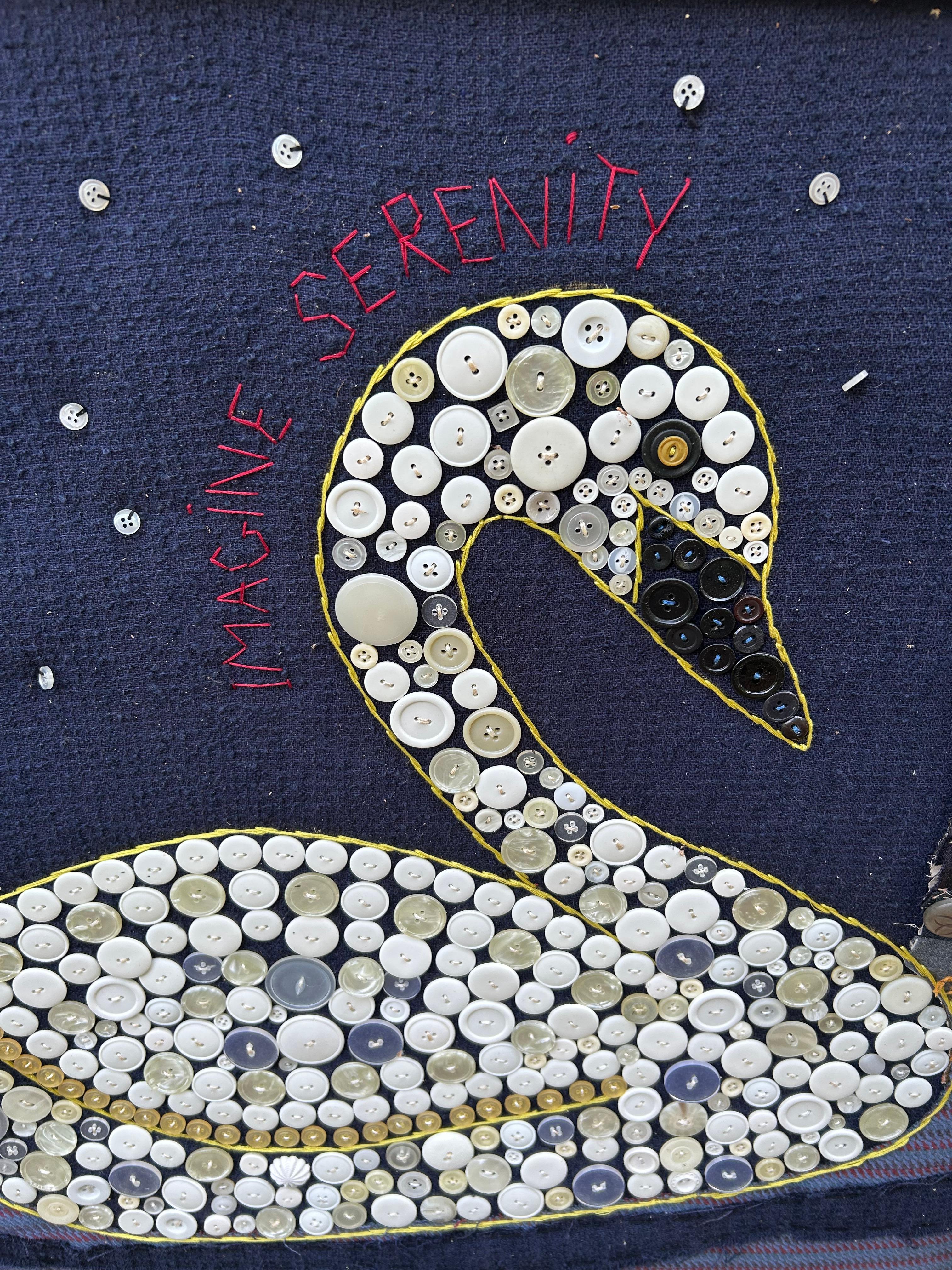 Art populaire inspirant de l'artiste du Maine Mary Teeter représentant un cygne orné d'un bouton et le message brodé Imagine Serenity.  Nous avons 3 de ses pièces disponibles.