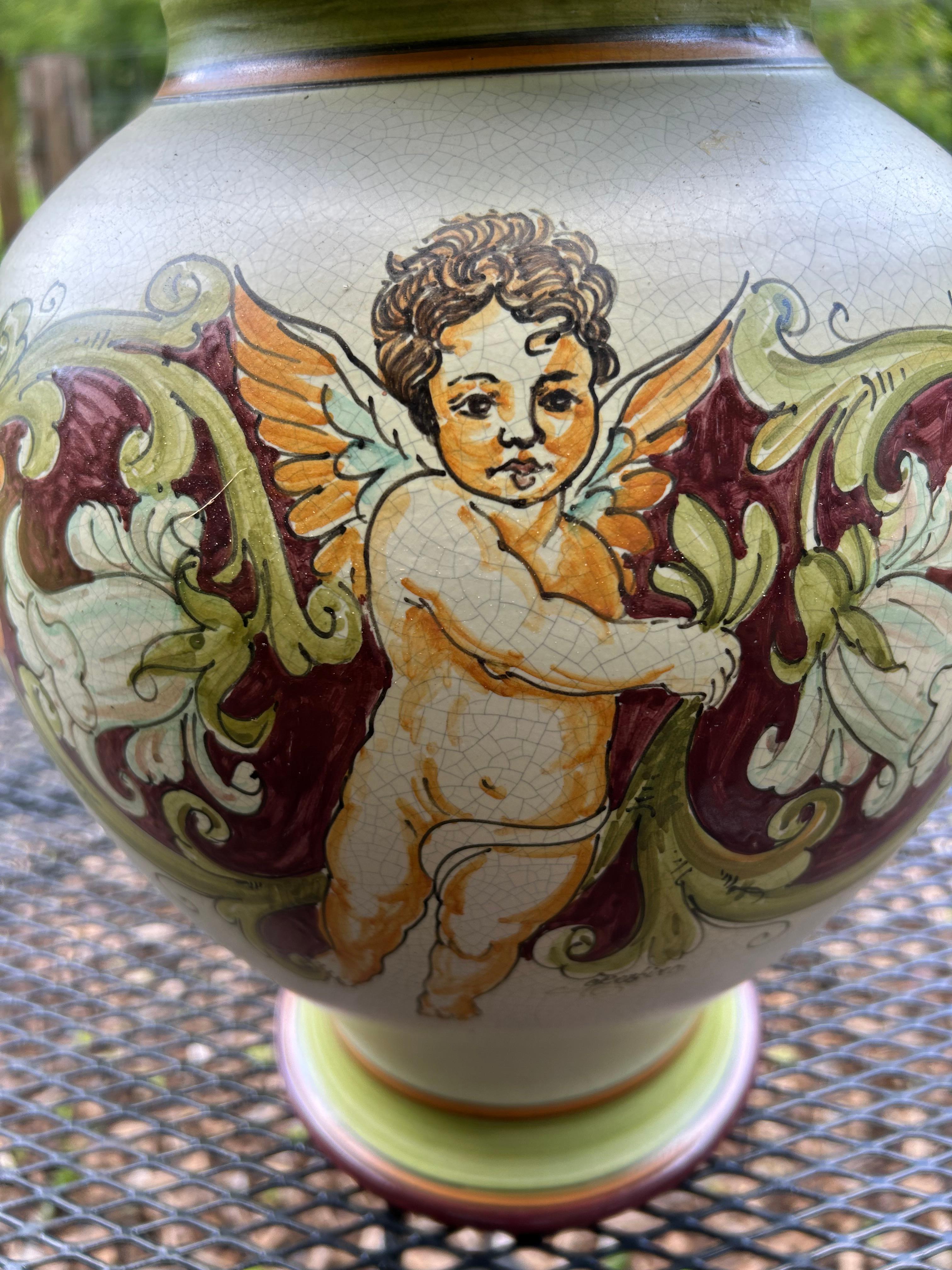 Grande urna romantica con coperchio in ceramica dipinta a mano, proveniente dalla Calabria, con cherubino e fogliame nei colori della terra su uno sfondo color crema.  Trovato in un negozio di antiquariato all'estero circa 25 anni fa.