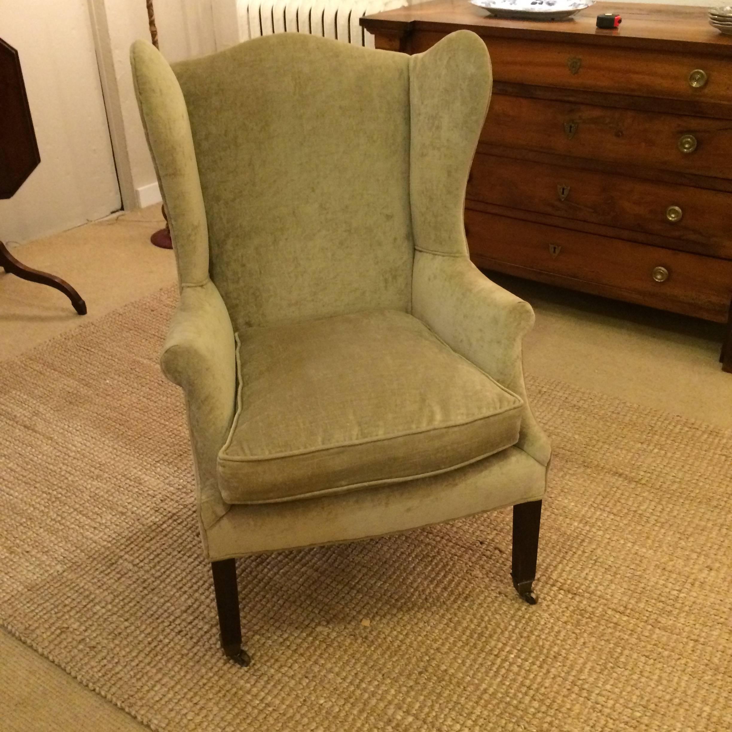 Classically elegant wing chair with mahogany legs and brass casters, newly upholstered in neutral soft sage green velvet with down cushion.
Arm width 29.
Back width 27.
seat width 21.