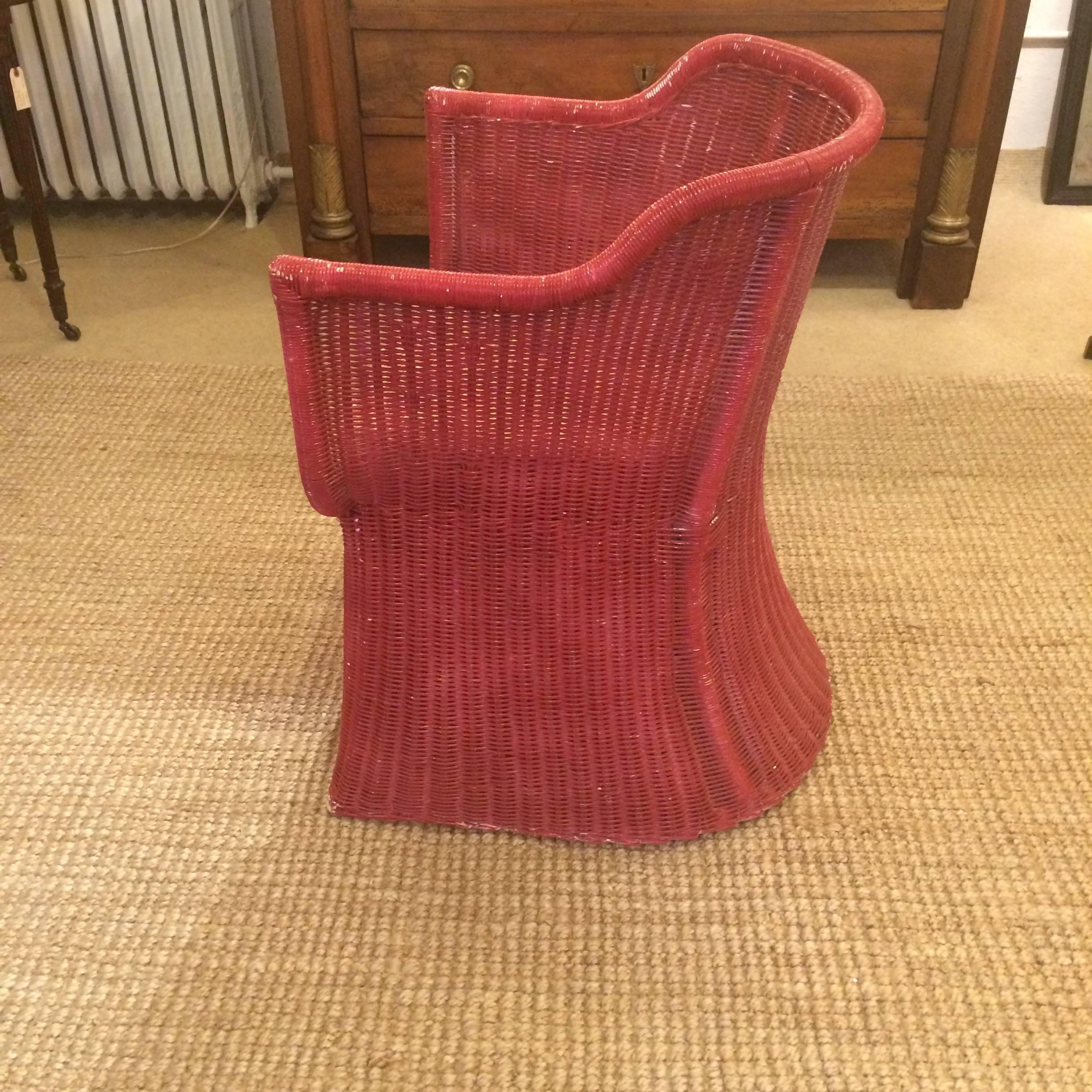 Delightfully shaped vintage wicker chair, beautiful from every angle, having a naturally aged patina to it's cranberry red oxide finish, and a fun Hermes style print cushion with dozens of monkeys.