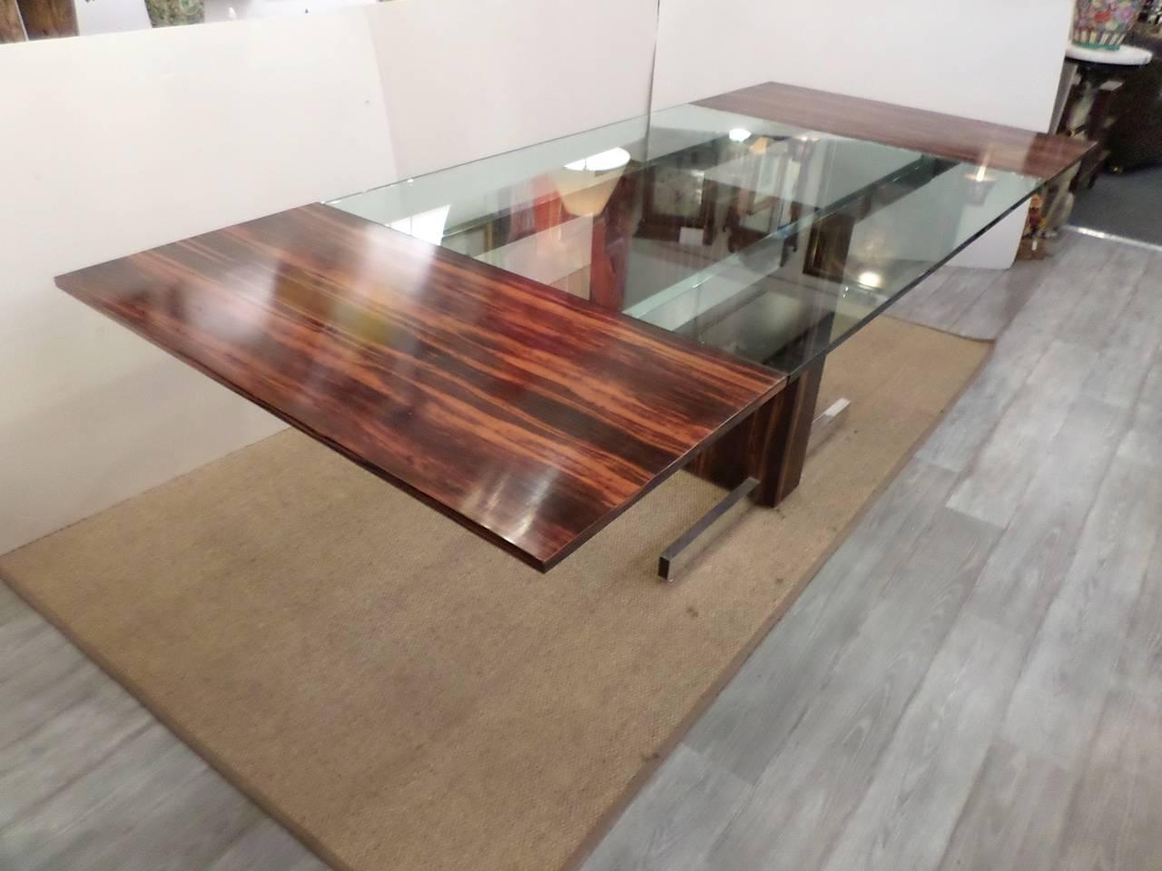 Stunning Mid-Century Modern dining table or conference table with rosewood veneer leaves at either end, polished aluminum, brass and a sleek design where the two leaves can lift off to become a glass top table. 
Fully extended: 29 1/2" x