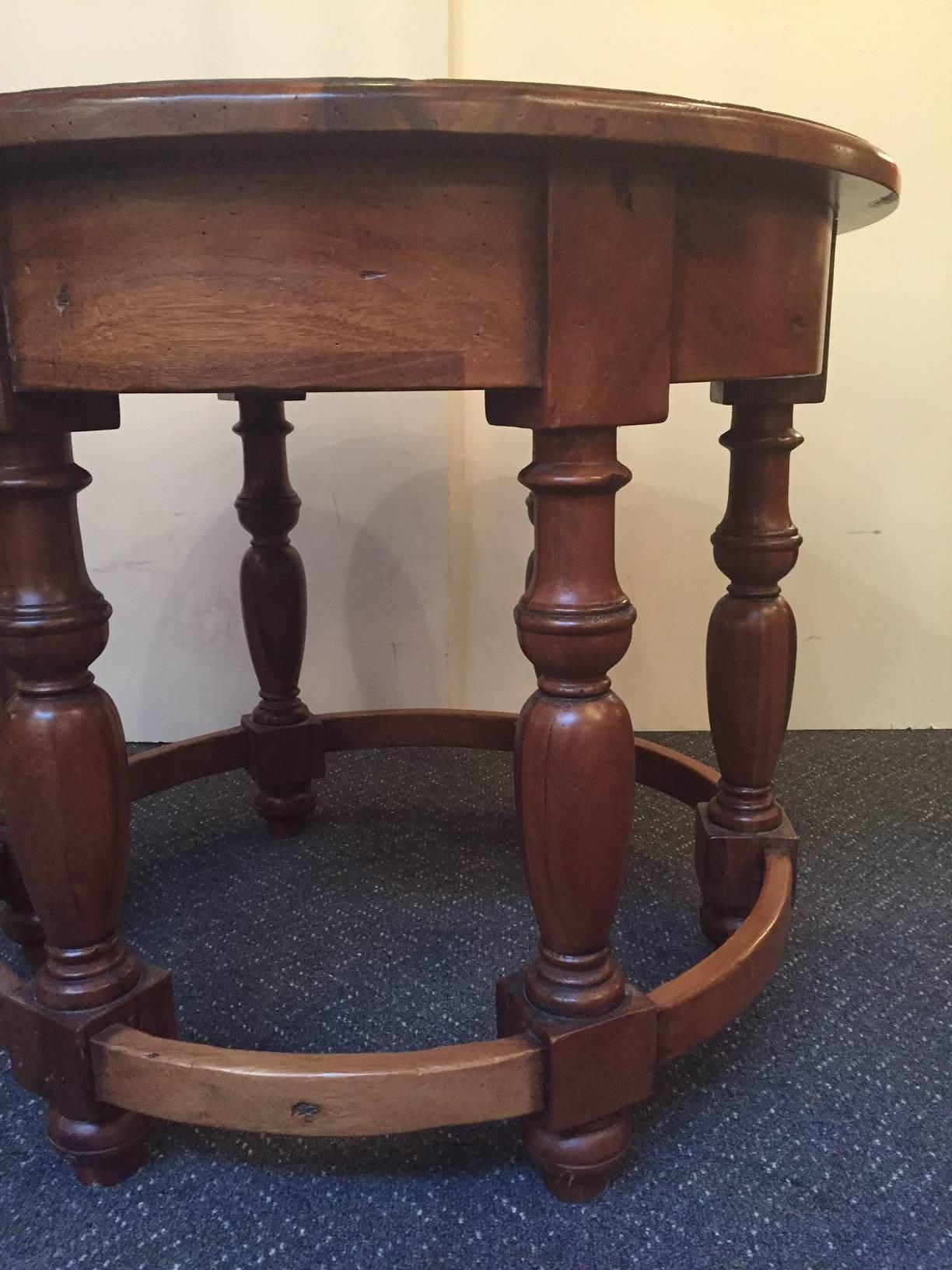 Handsome round center hall table with a Jacobean style, about 30 years old, having six elaborately turned legs and a beautiful wooden circular base that runs through the bottom of the legs.

RR
                