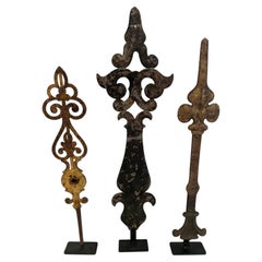 Collezione di 3 sculture di lancette di orologi antichi realizzate con oggetti di recupero, su piedistalli