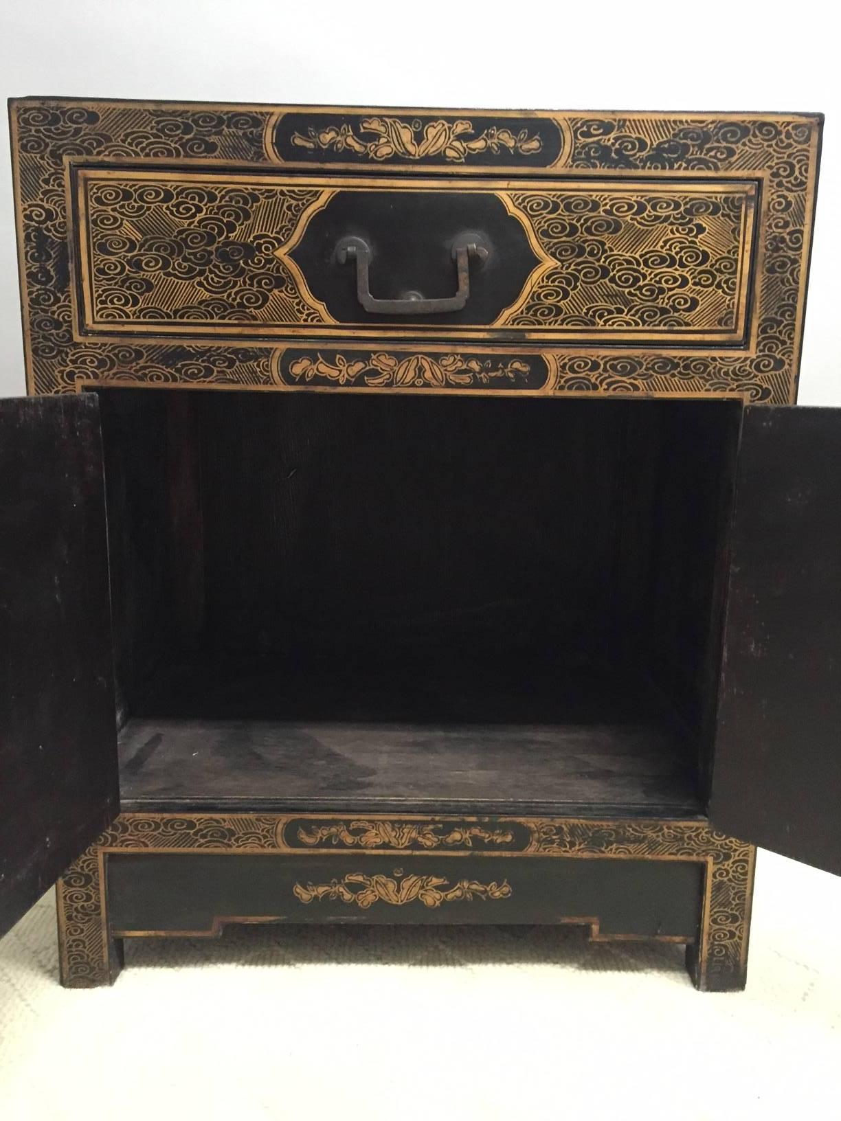 Two elegant black laquer hand-painted Chinese chests having gold detailed figures in a Classic chinoiserie landscape that are unique on each chest and compliment one another. There's a single drawer on top with two doors underneath that open to