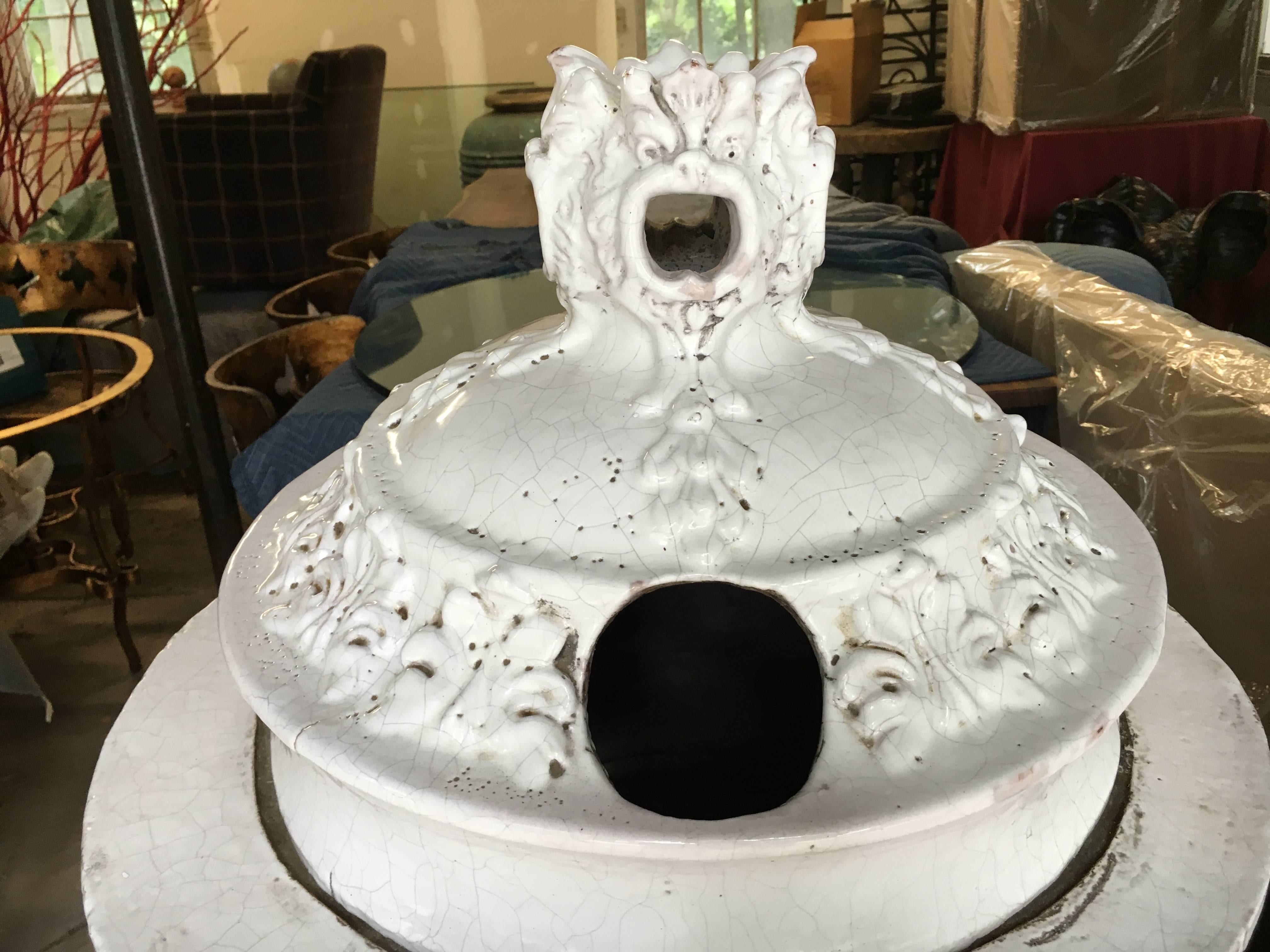 A fine 19th century French faience stove in glazed white ceramic, having decorative rosettes and faces. Consists of three sections (which stack upon each other), and two metal doors. French, 19th century, good condition with minor chips. Measures: