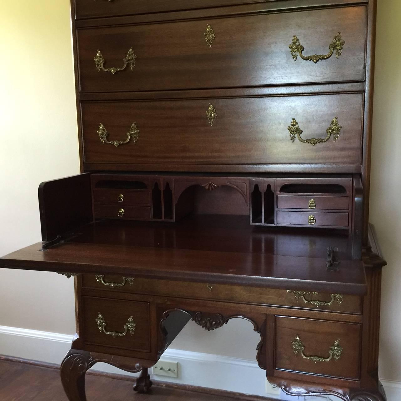 Elegant vintage Chippendale style highboy with with broken arch top and central finial, cabriole legs and ball and claw feet. Swan’s neck pediment, thumb-molded drawers and very pretty original brasses.

There are seven rows of dovetailed drawers
