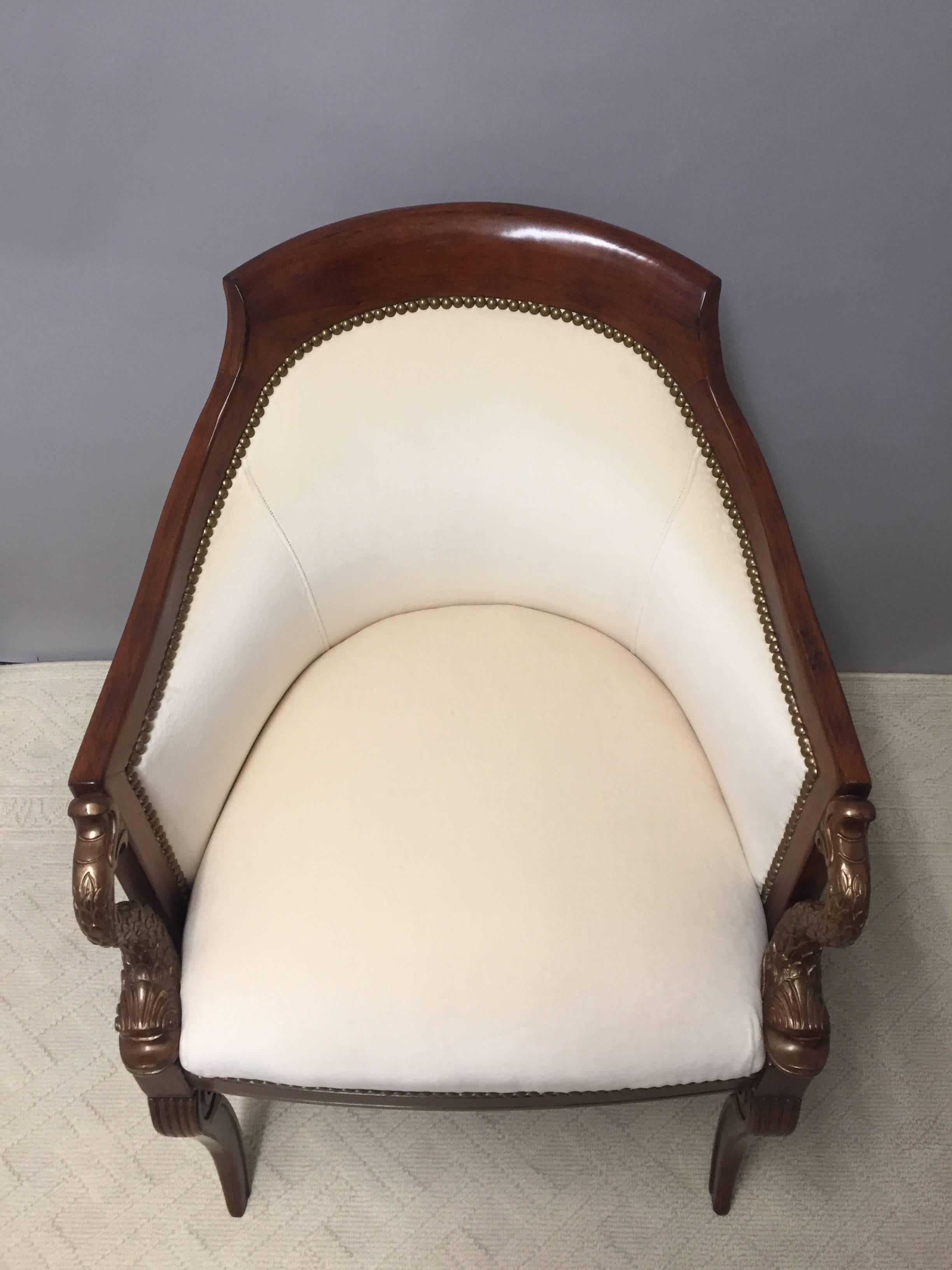 Very elegant pair of club/tub style chairs having a sensual curved back, gorgeous dark ornately carved mahogany frames with dolphins on the arms that have a subtle bronze metallic under finish and decorative scrolly legs.

RR
 