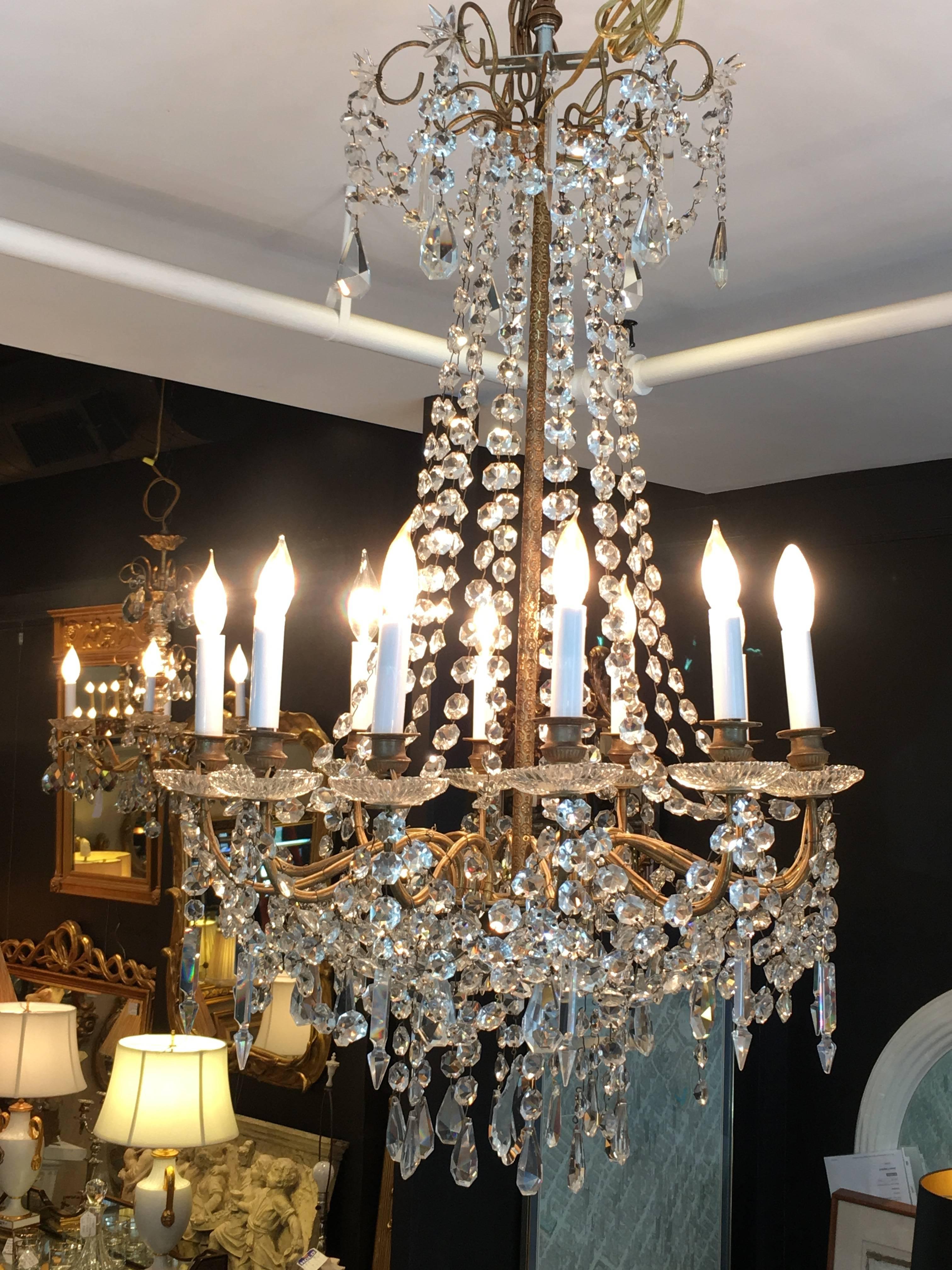 Elegant fancy French mpire chandelier dripping with crystals and having 12 arms, 40 watt each.
