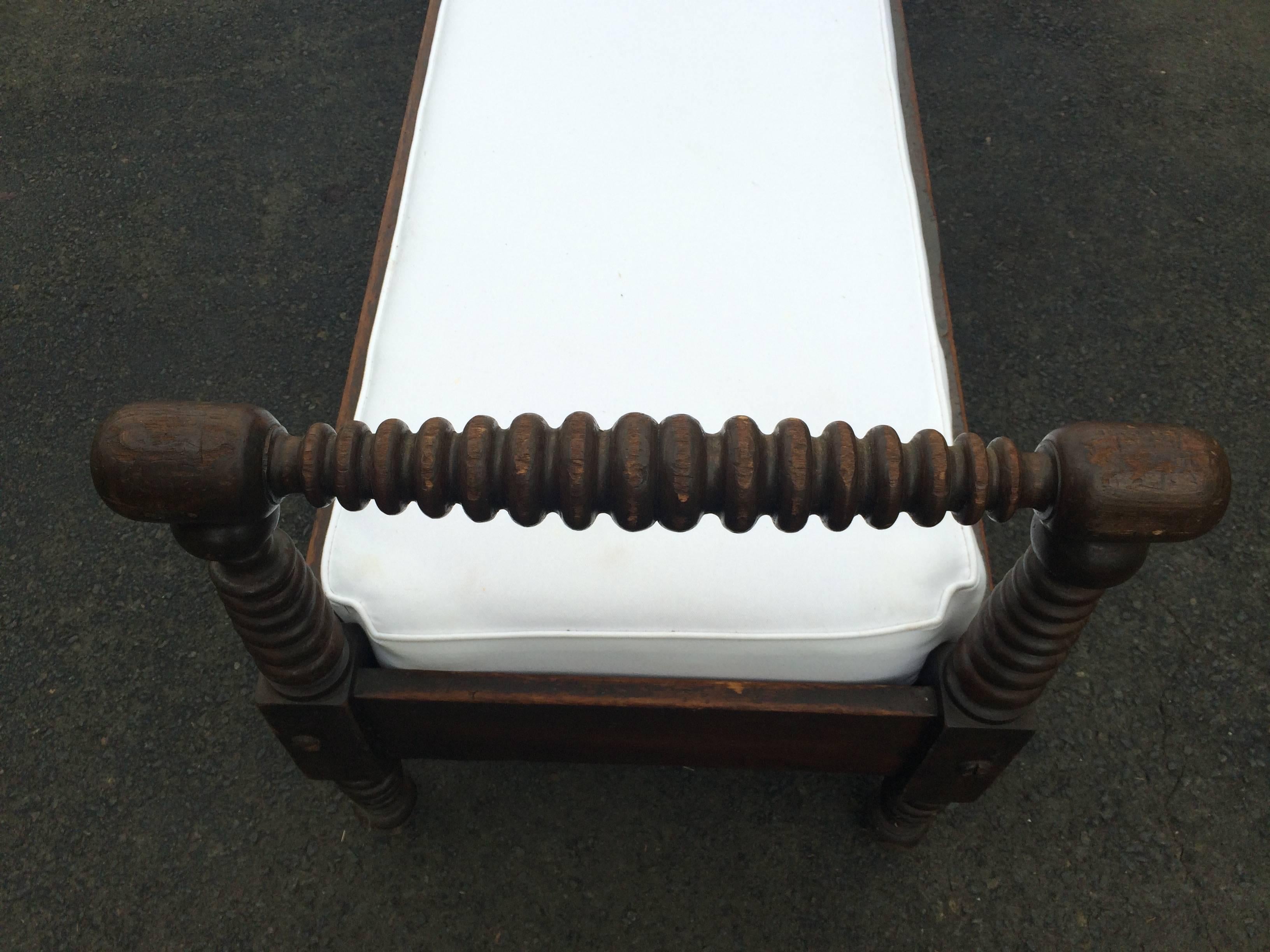 Handsome walnut daybed or low bench having hand-carved turned frame. Custom cushion.