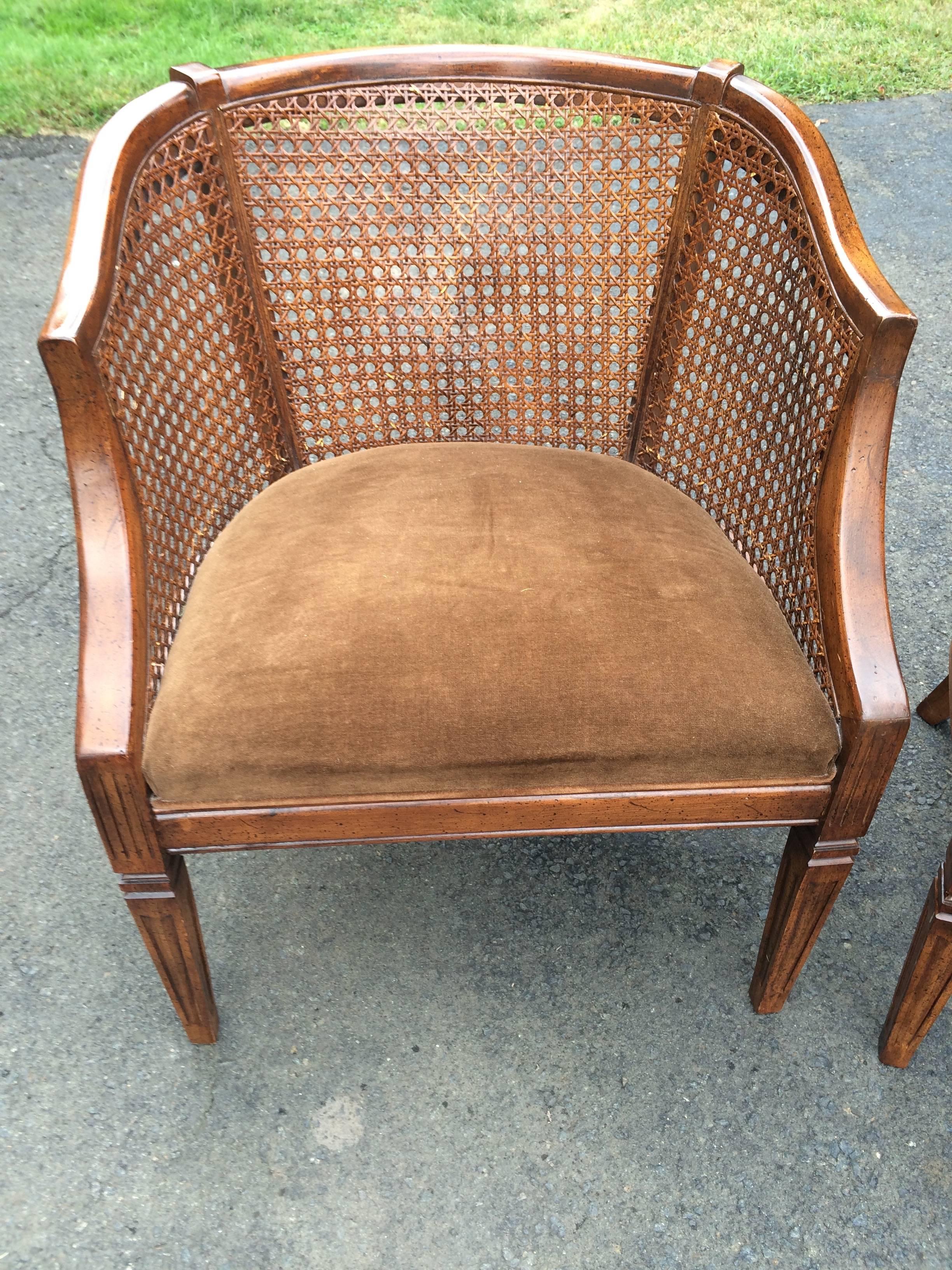 Handsome pair of chairs for the livingroom or library having rich carved wood and caned curved frames and luxurious brown velvet upholstered seats.